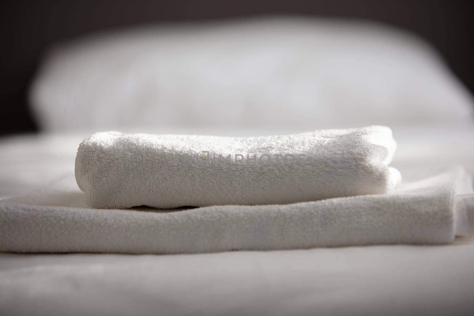 White clean towels stacked on the hotel bed by senkaya