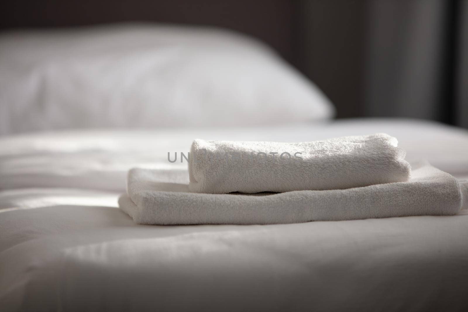 White clean towels stacked on the hotel bed. High quality photo