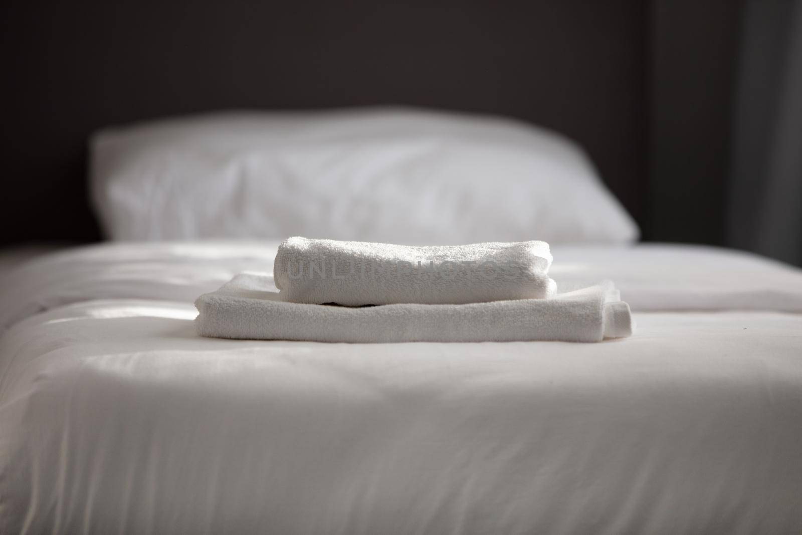 White clean towels stacked on the hotel bed by senkaya