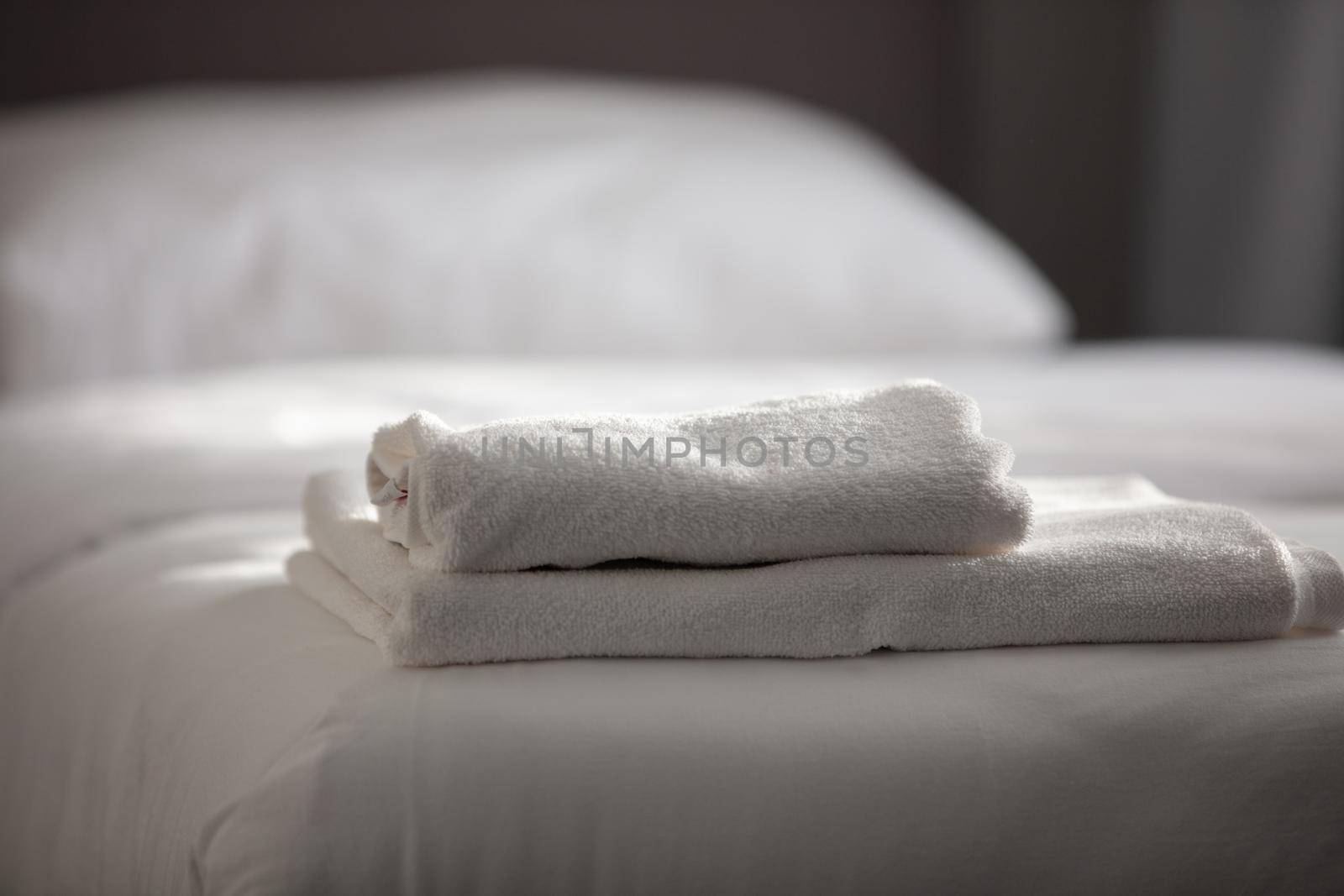 White clean towels stacked on the hotel bed. High quality photo