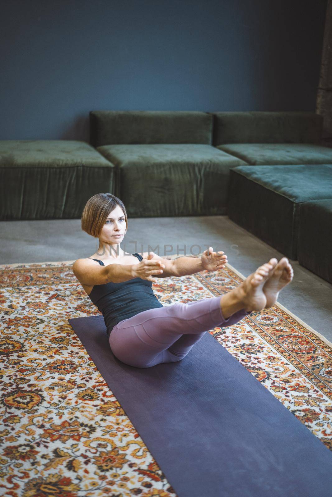 Caucasian Woman Practicing Yoga at Home. Beautiful Woman Standing in Warrior one Pose, Virabhadrasana. Full Length. Close-up. High quality photo