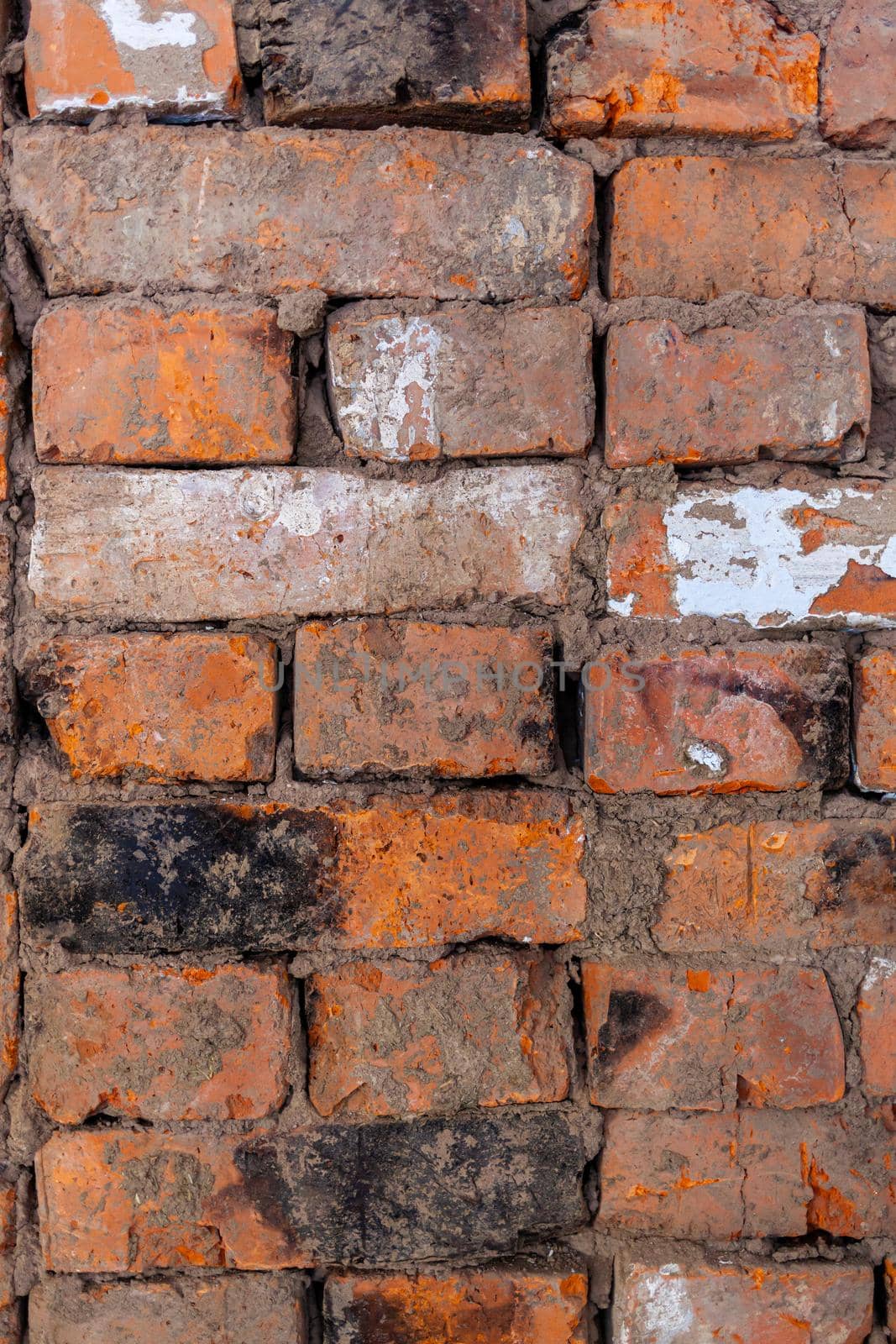 Different red bricks are laid in the wall after repair. by AnatoliiFoto