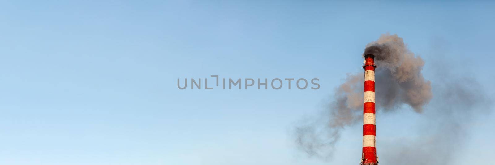 White thick smoke from the boiler room chimney. Industrial zone.Banner by AnatoliiFoto