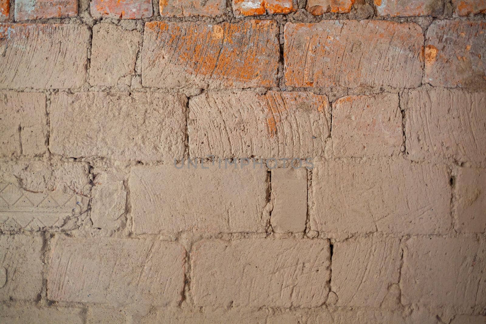 Repair of an old brick wall of a home stove. Different red bricks are laid in the wall after repair. Brick background