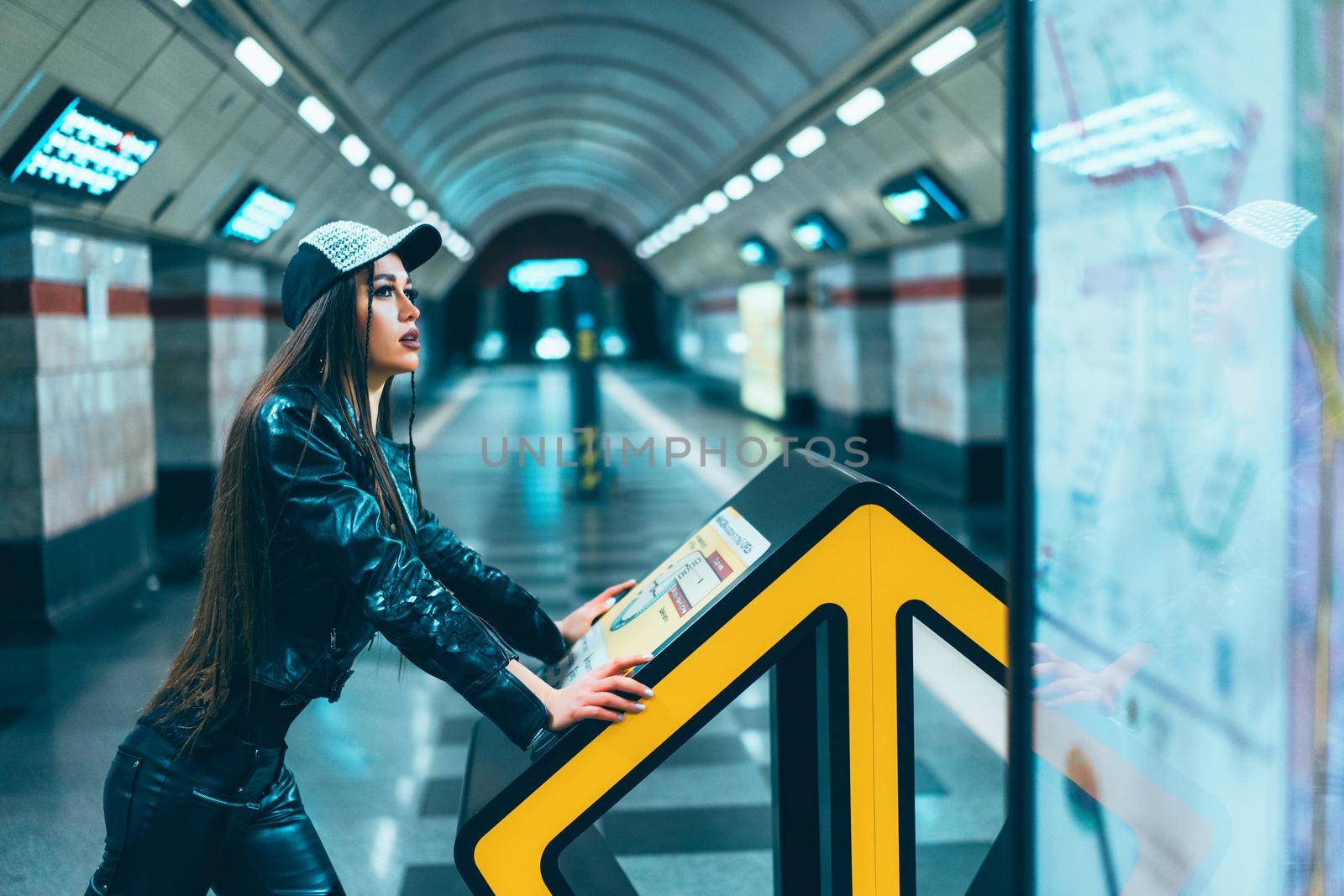 Fashion Style Model Female Of 20s Posing on Subway Station Platform. Gorgeous Brunette Woman Looks at the Metro Map in the Platform of the Empty Station. Close-up. High quality photo