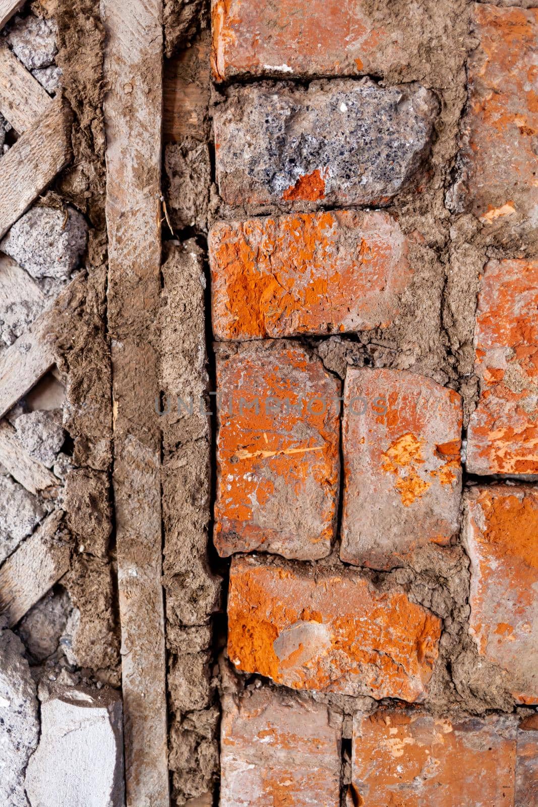 Repair of an old brick wall of a home stove. Different red bricks are laid in the wall after repair. Brick background