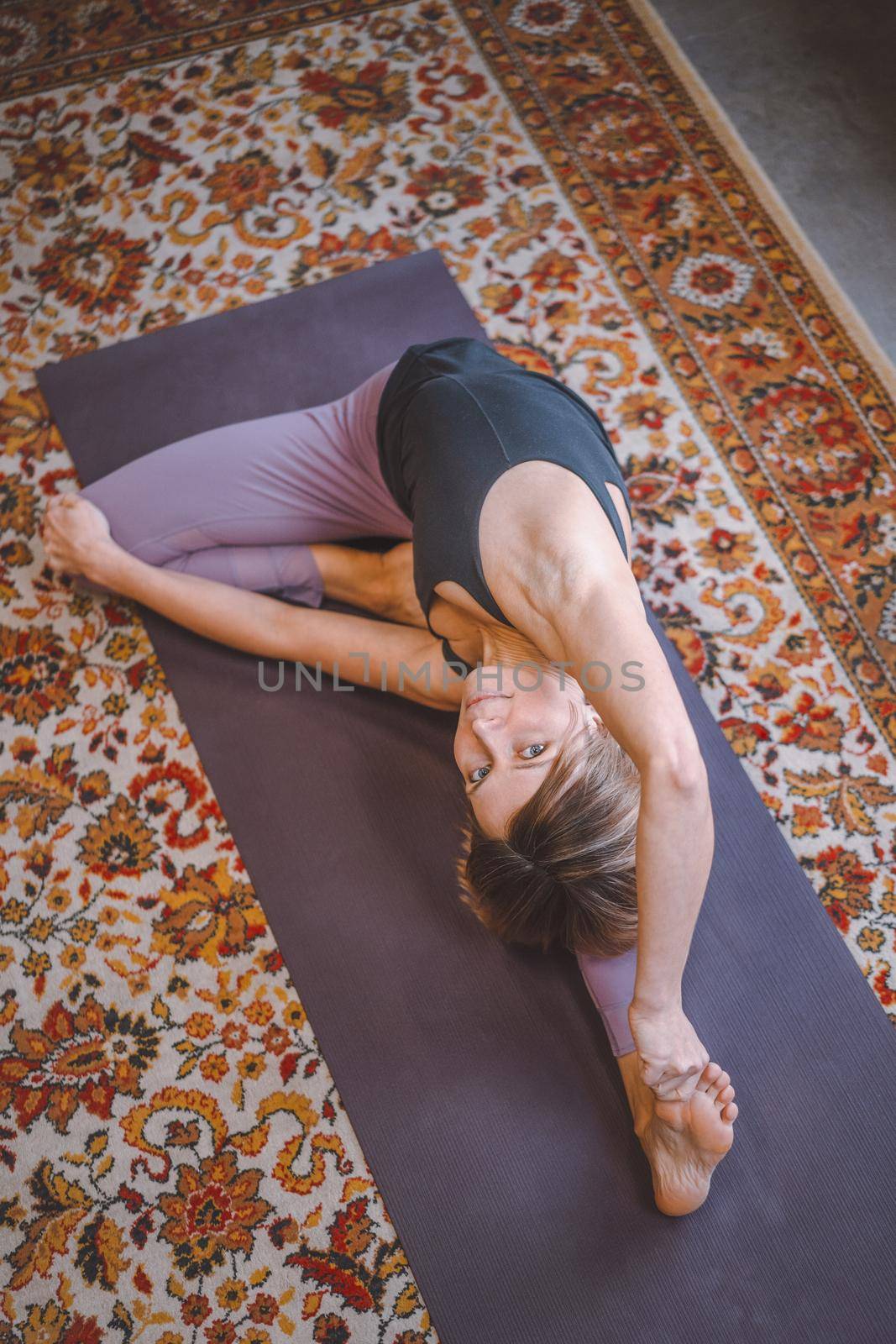 Woman is engaged in yoga. Stretching while looking at the camera. The concept of self-love, care, positive, energy. High quality photo