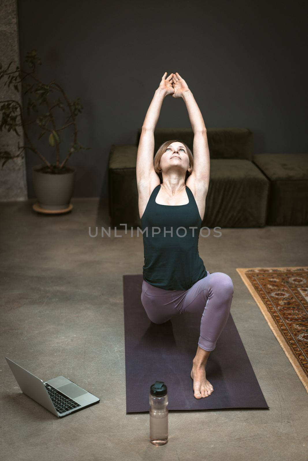 Caucasian Woman Practicing Yoga at Home. Beautiful Woman Standing in Warrior one Pose, Virabhadrasana. Full Length. Close-up. High quality photo