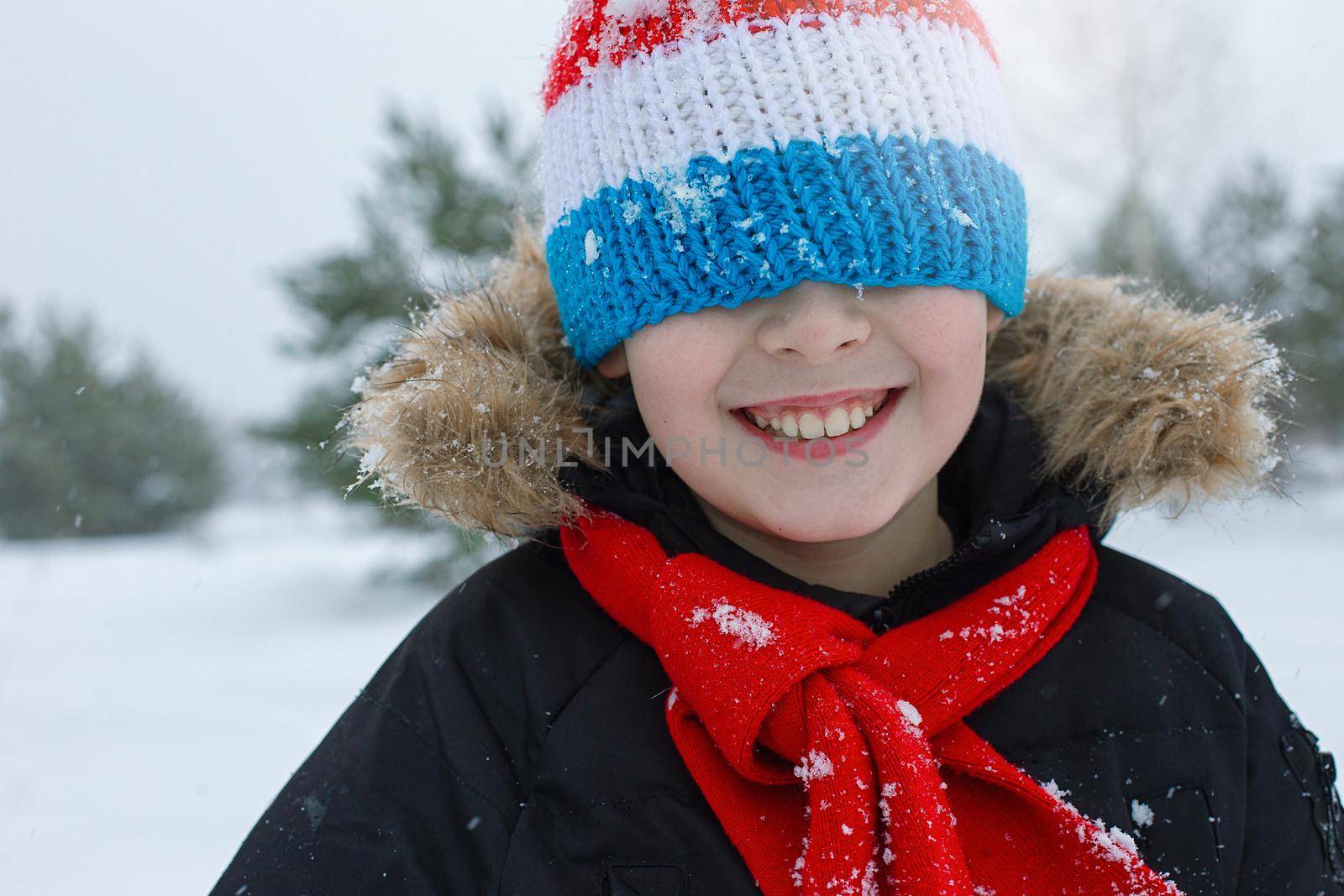 Happy boy in bright winter clothes and a red scarf by Zakharova