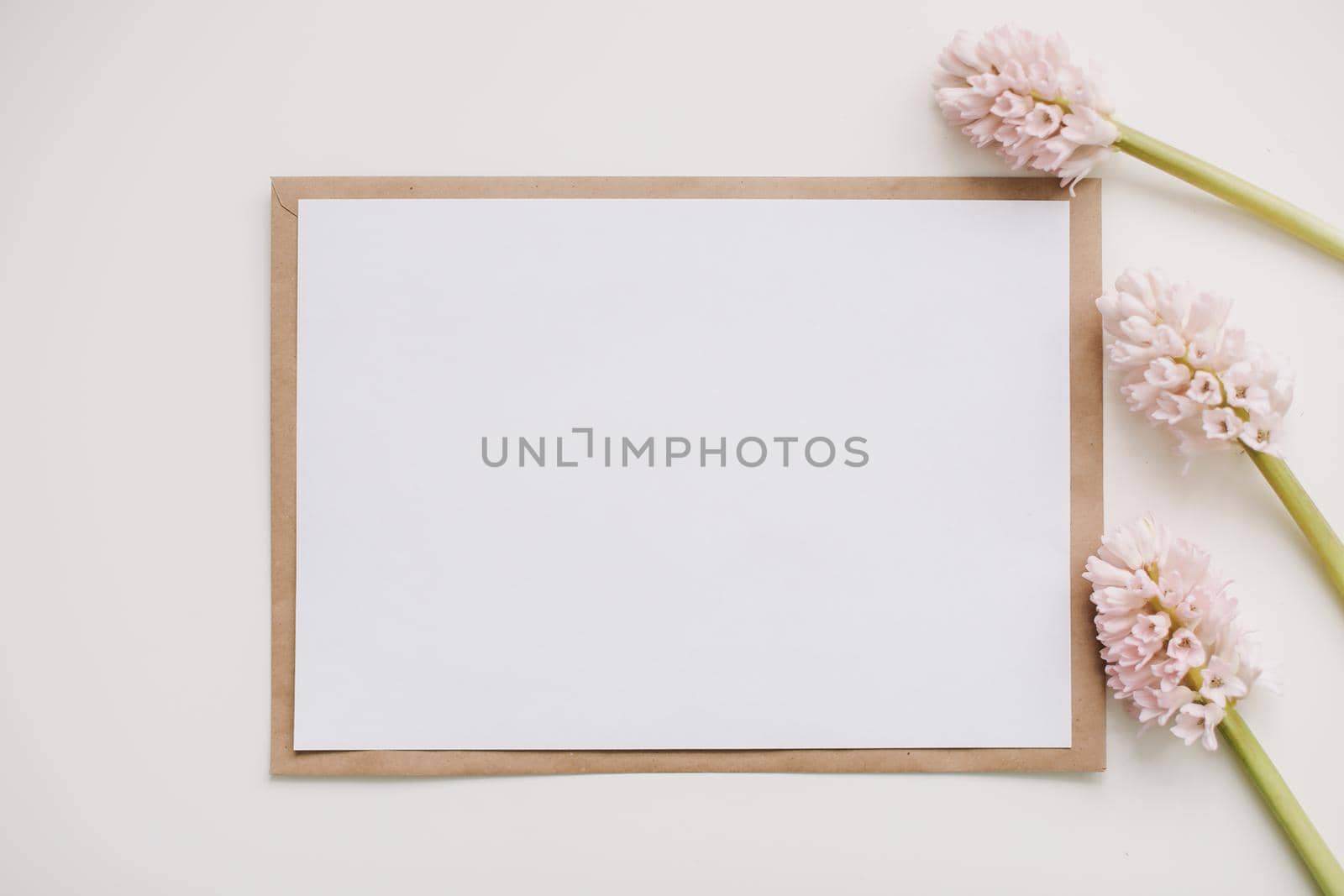  composition with pink flowers and blank paper card, mockup, invitations. Flatlay, top view, copy space. Creative concept, empty greeting card. 