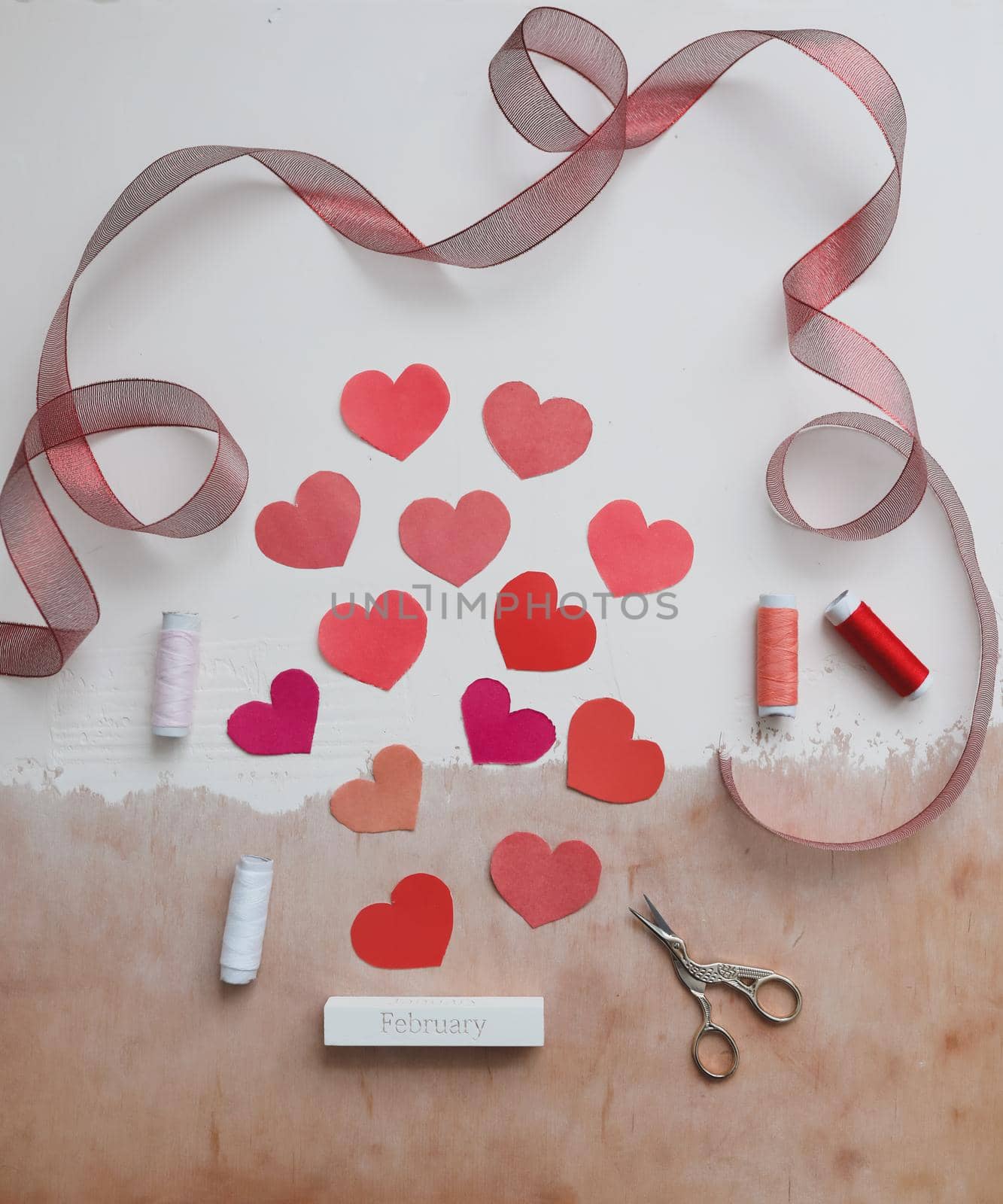 Love Background with paper hearts and red ribbon. Space for text on white background. Valentines day concept. Greetings. Copy space. Flat lay, top view. 
