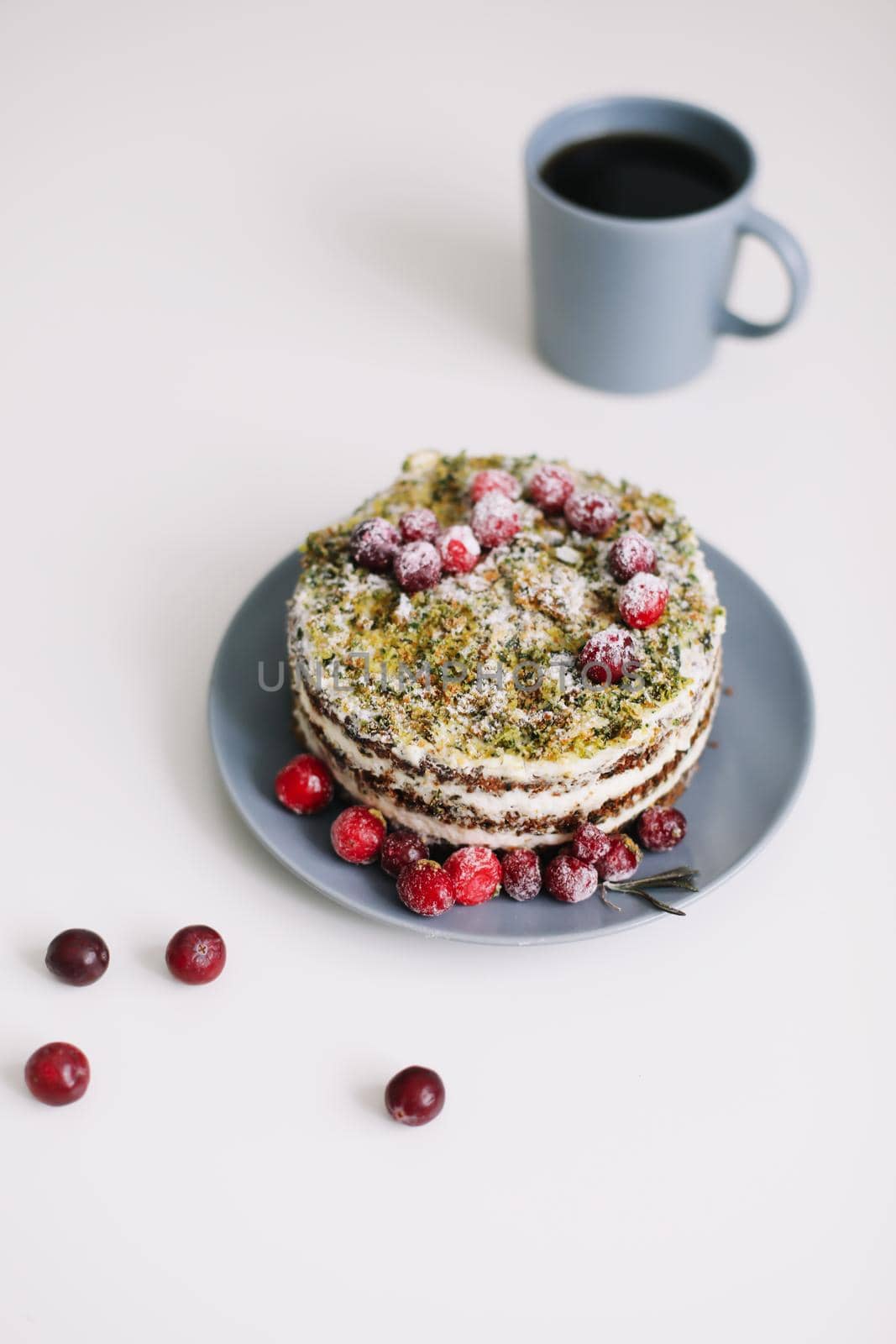 homemade cake with spinach and cream decorated with fresh cranberries on white table, diet breakfast by paralisart