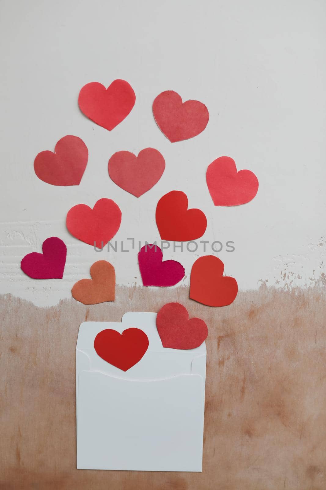 envelope with red paper hearts on a white background. Hearts take off from inside open envelope. Romantic love letter. Valentine's Day concept. Flat lay, top view. banner, copy space. 