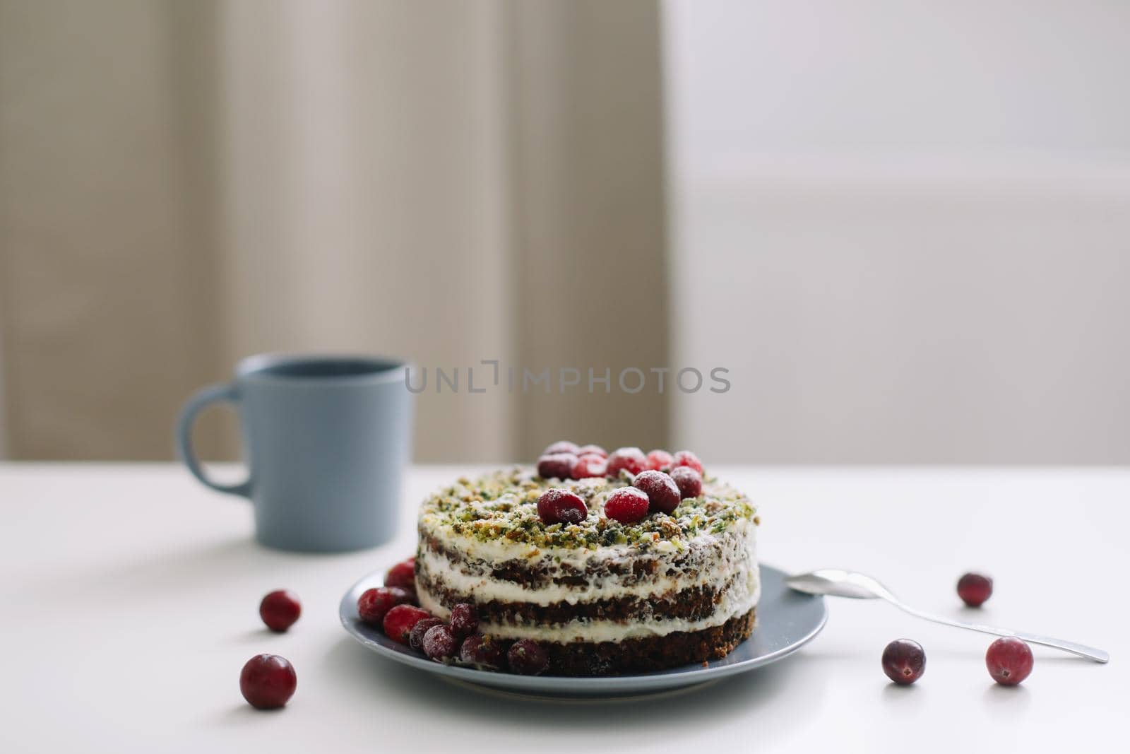 homemade cake with spinach and cream decorated with fresh cranberries on white table, diet breakfast by paralisart