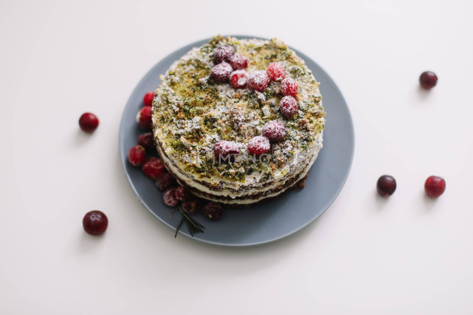 homemade cake with spinach and cream decorated with fresh cranberries on white table, diet breakfast by paralisart