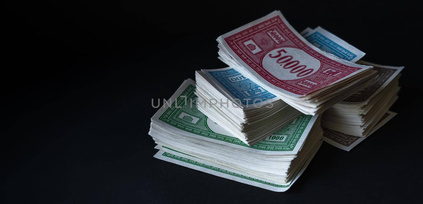 Stack of fake banknotes on black background.