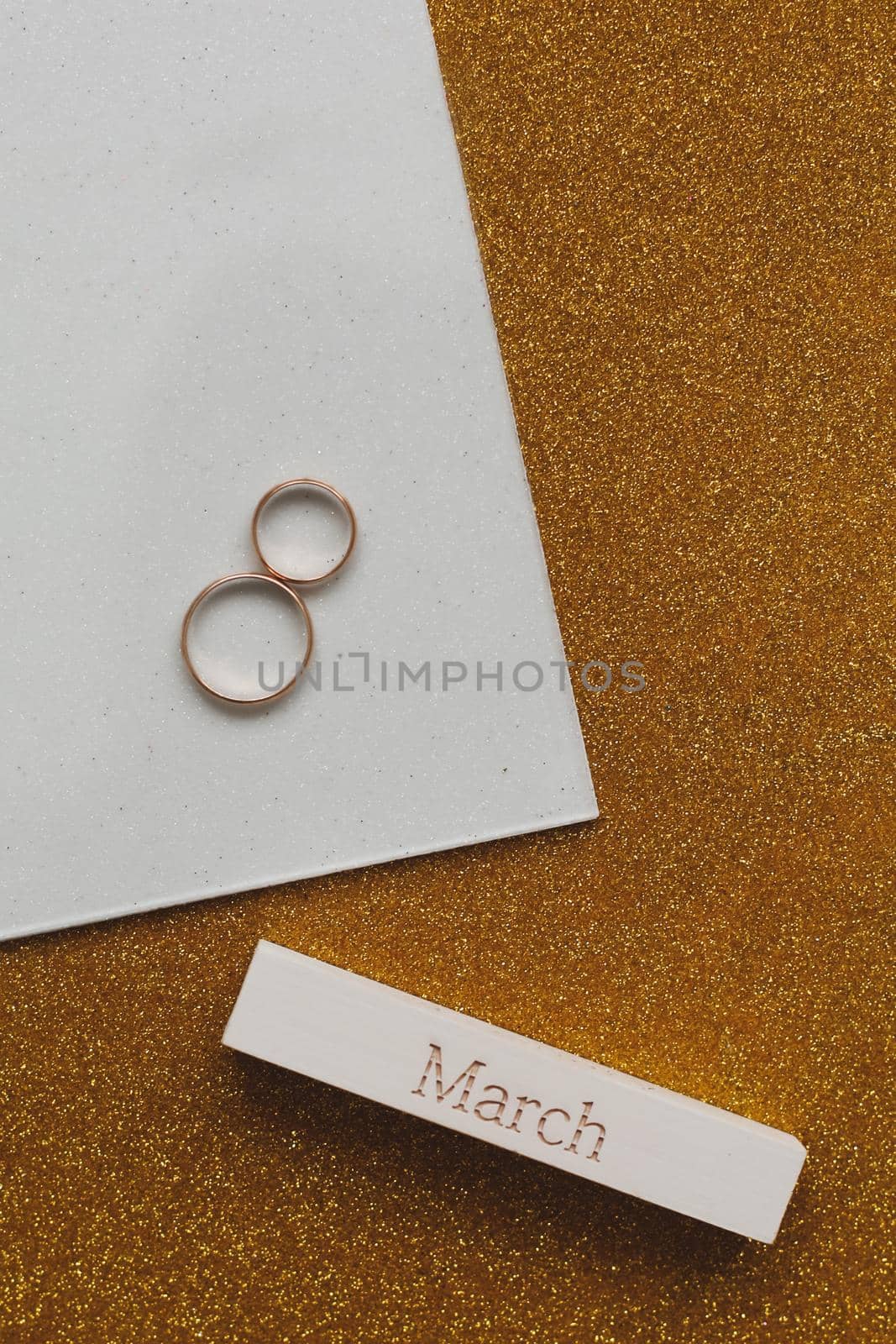  Eight made of two gold wedding rings and word MARCH. Greeting card for March 8. Flat lay, top view, copy space