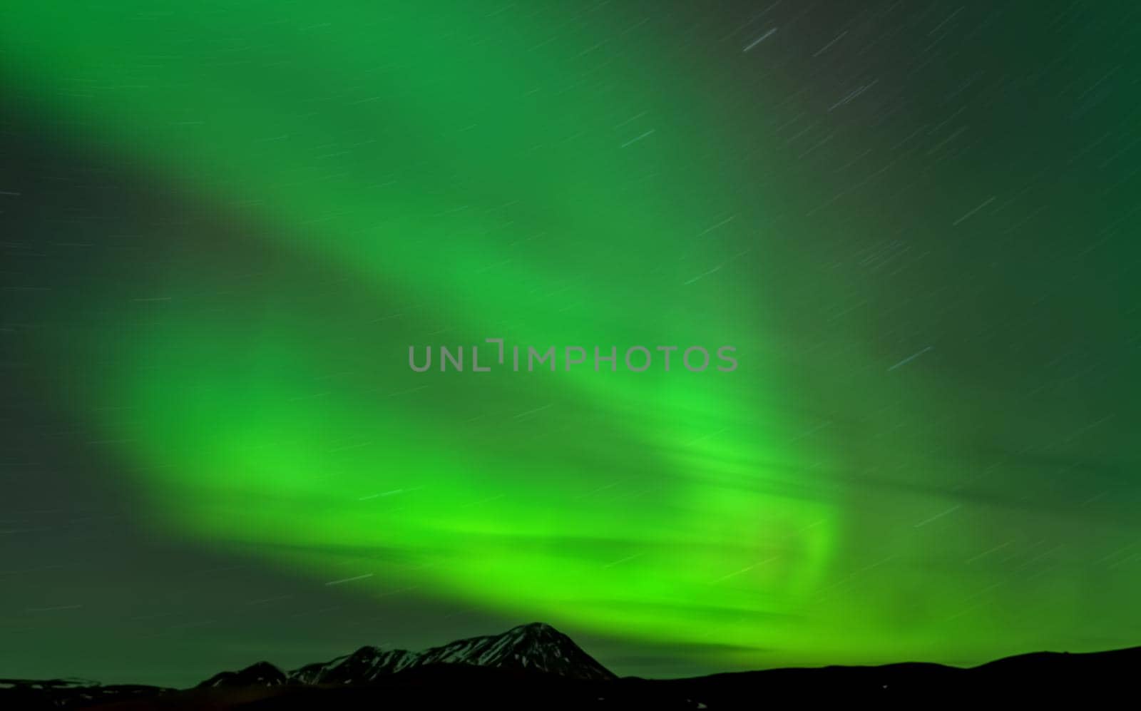 Aurora borealis star trail and mountain peak