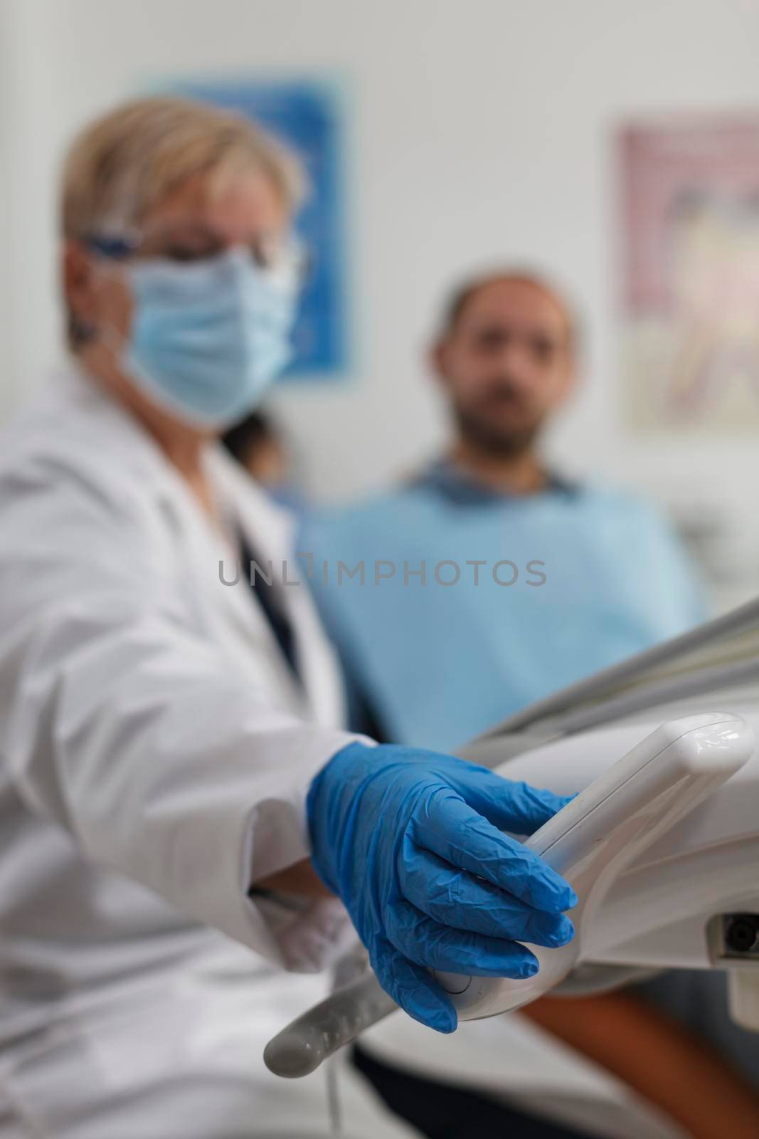 Closeup of senior woman dentist working at teeth procedure by DCStudio