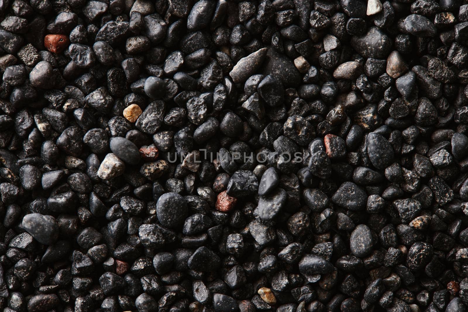 Texture of black volcanic sand for background. Black Sand beach macro photography. Close-up view of volcanic sand surface. Icelandic Black Sand macro photography. Black pebble background.