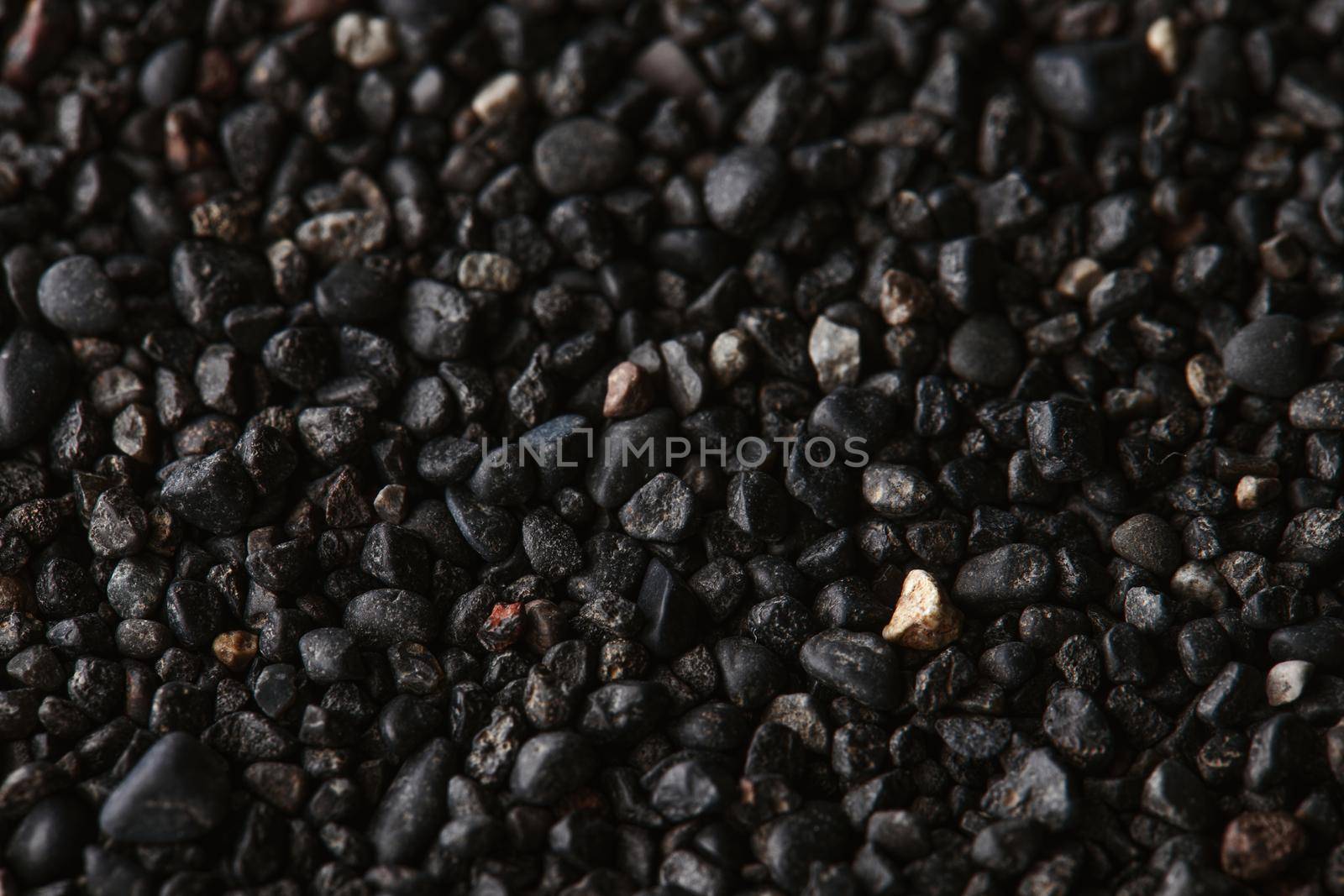 Texture of black volcanic sand for background. Black Sand beach macro photography. Close-up view of volcanic sand surface. Icelandic Black Sand macro photography. Black pebble background by EvgeniyQW