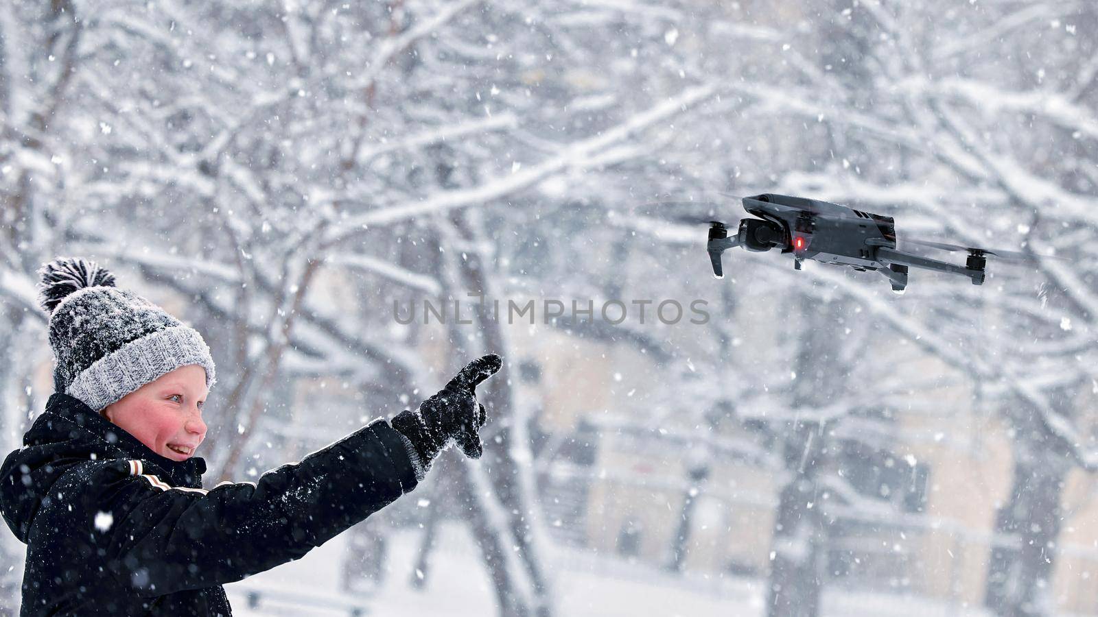 Teenager boy dressed winter jacket and modern digital drone DJI Mavic, flying in snow conditions. DJI Mavic 3 most portable drones with Hasselblad camera. 25.01.2022 Rostov-on-Don, Russia.