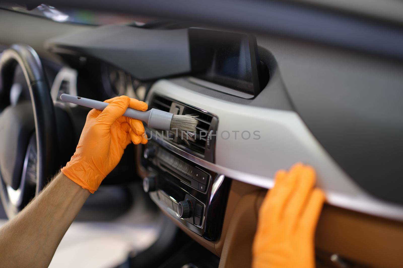Mechanic cleaning air duct of cars with brush closeup. Car dry cleaning concept