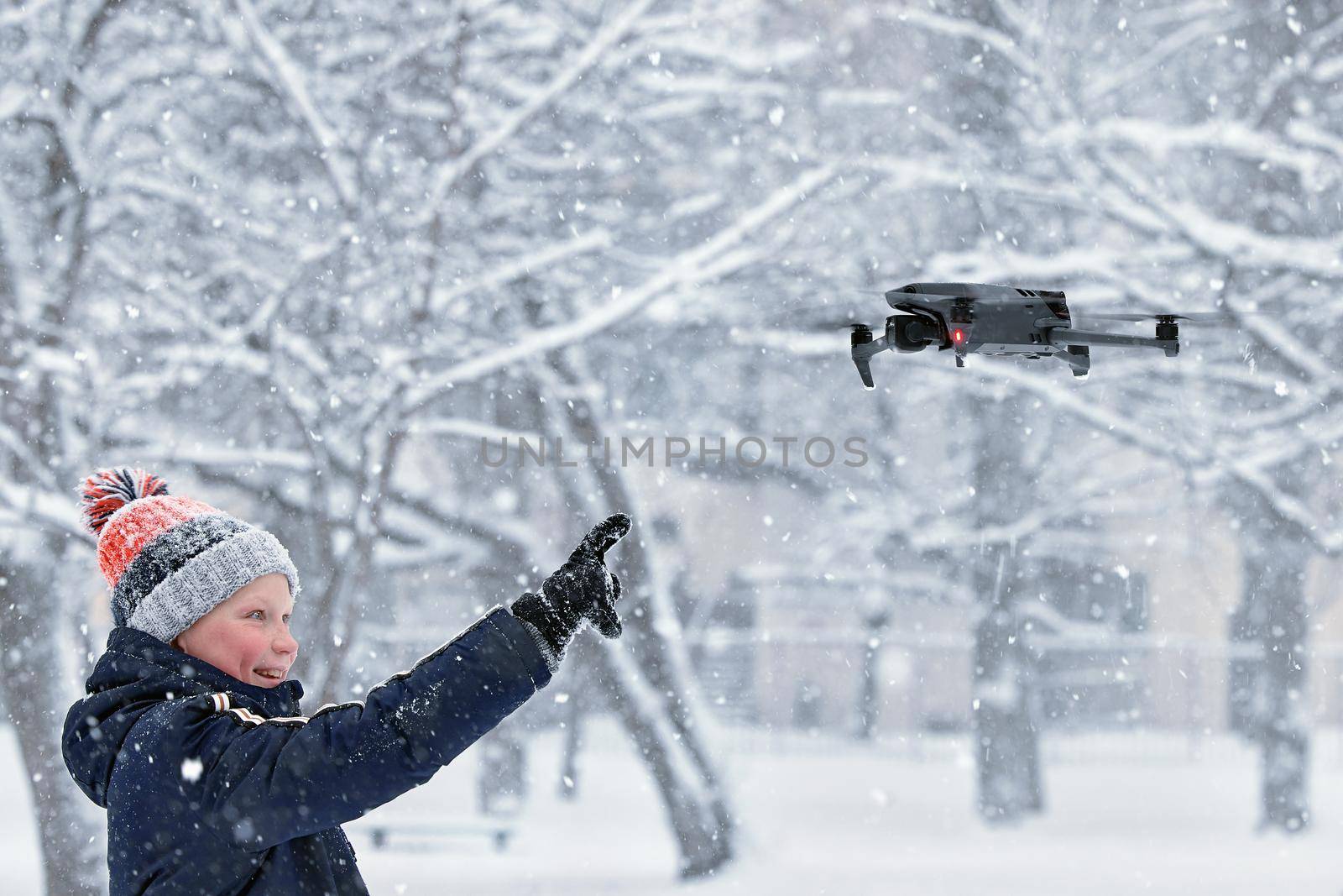 Teenager boy dressed winter jacket and modern digital drone DJI Mavic, flying in snow conditions. DJI Mavic 3 most portable drones with Hasselblad camera. 25.01.2022 Rostov-on-Don, Russia by EvgeniyQW