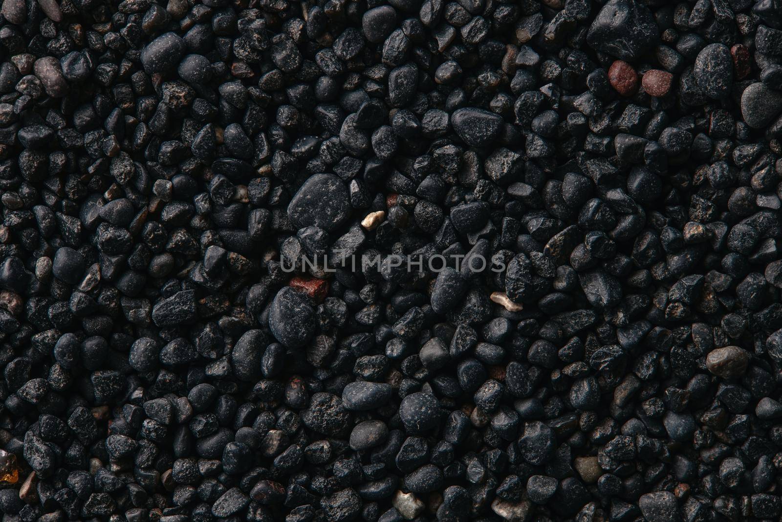 Texture of black volcanic sand for background. Black Sand beach macro photography. Close-up view of volcanic sand surface. Icelandic Black Sand macro photography. Black pebble background.