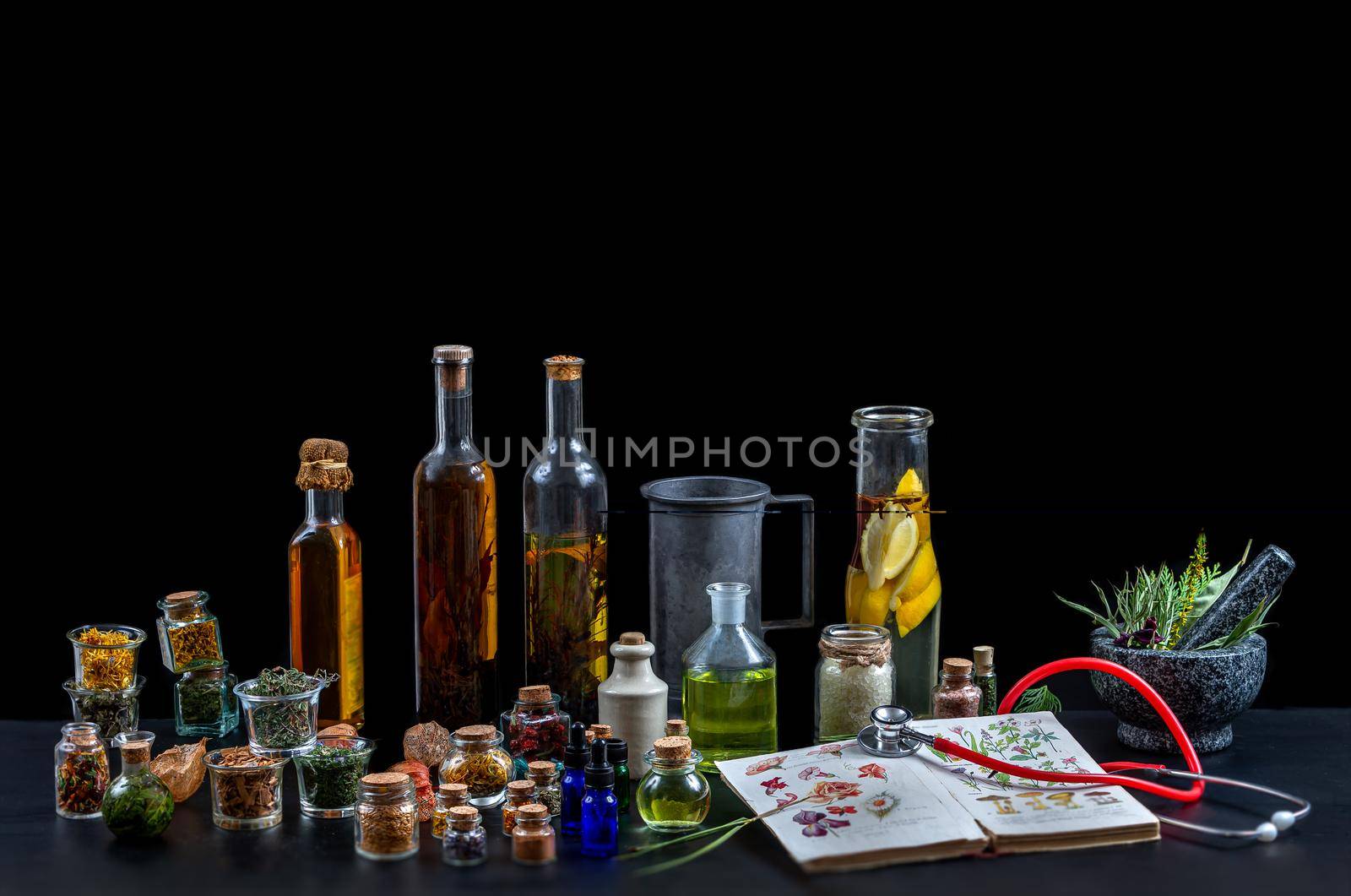 Panel of natural medicines from plants with an old book covered with stethocope