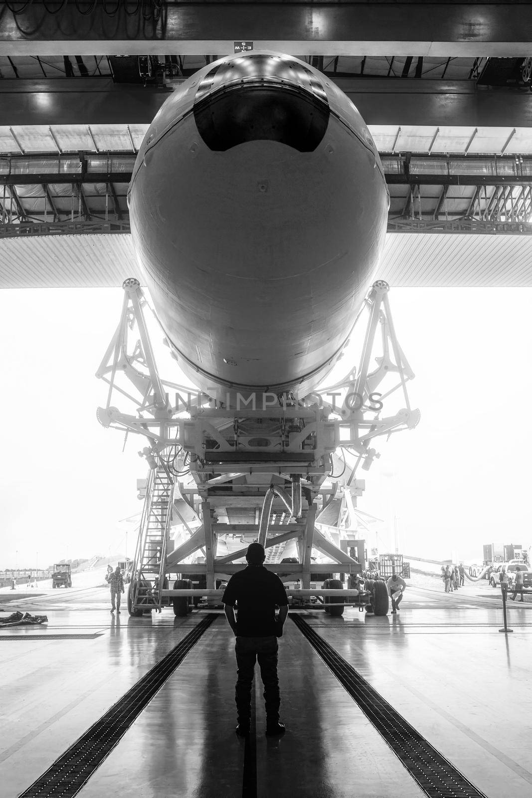 Space engineer looks at a built spacecraft. Rocket with spacecraft, rolls out of the hangar. Space launch preparation. rocket, inside the maintenance hangar. Elements of this image furnished by NASA.