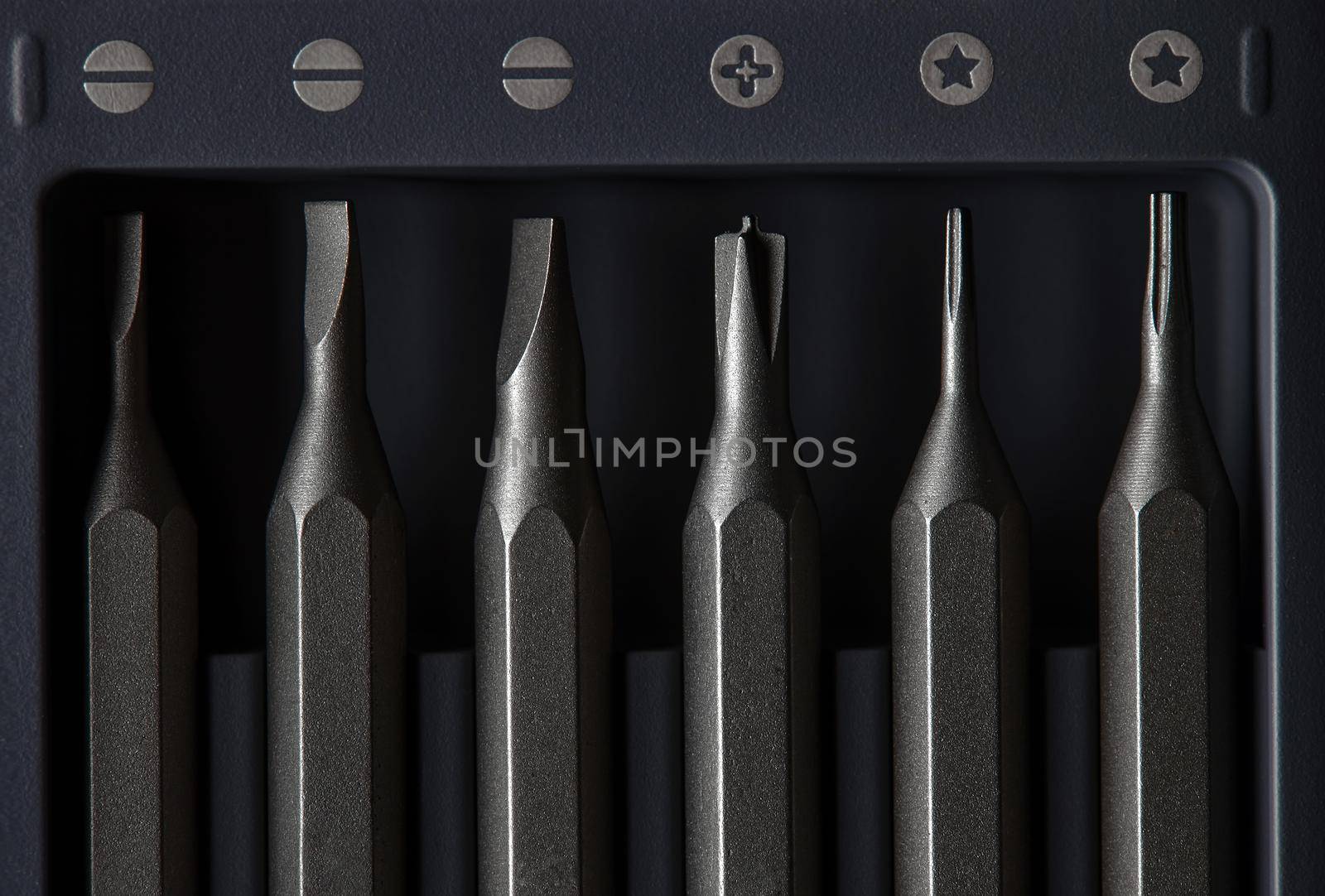 Screwdriver tips different shapes and sizes close up. Manual metal mini screwdriver and set of the interchangeable bits. Precision Screwdriver Kit. Steel Precision Magnetic Bits.