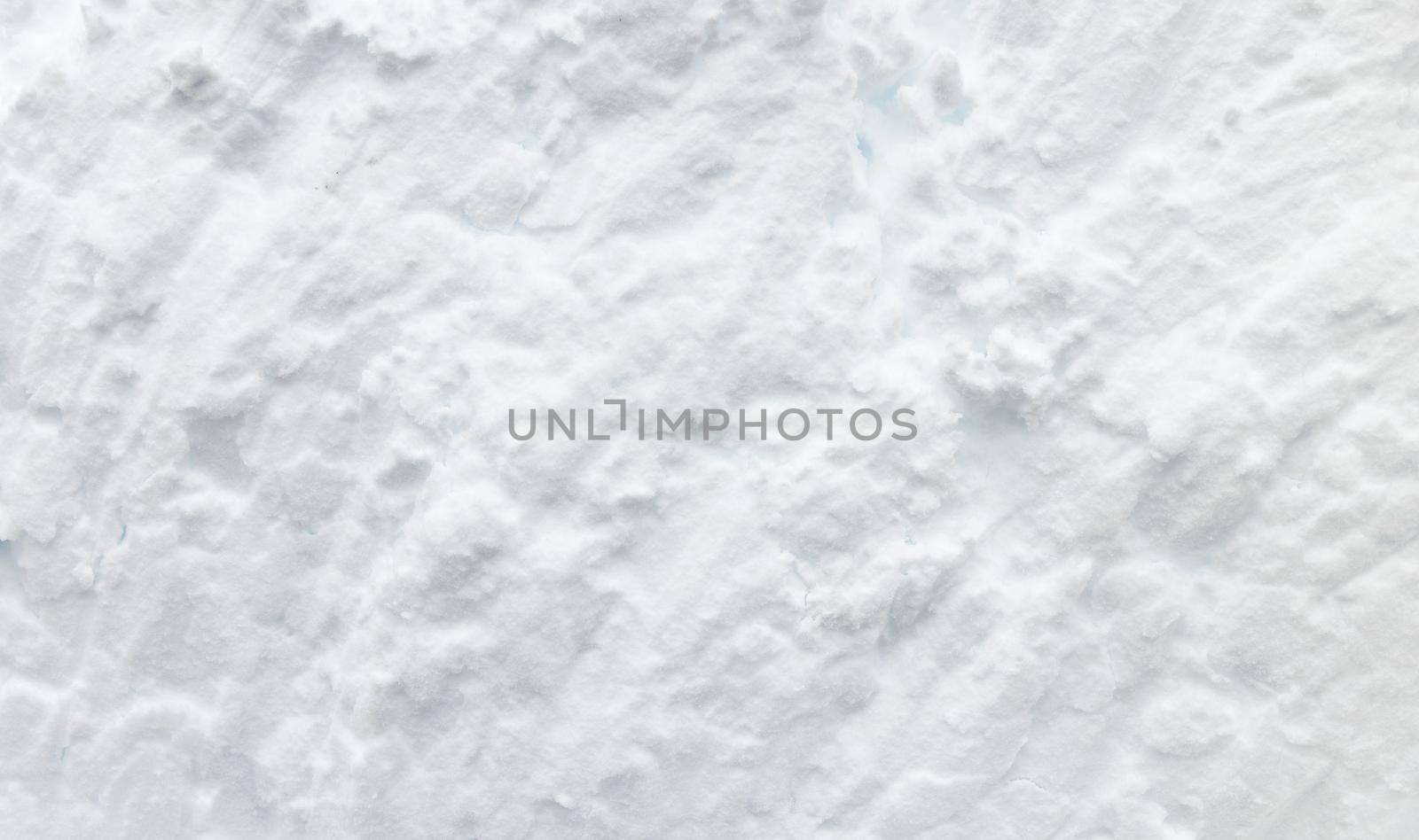 Wall of snow. Snowdrift surface, Winter background. The texture of snow removed with a bucket. Removed compressed snow.