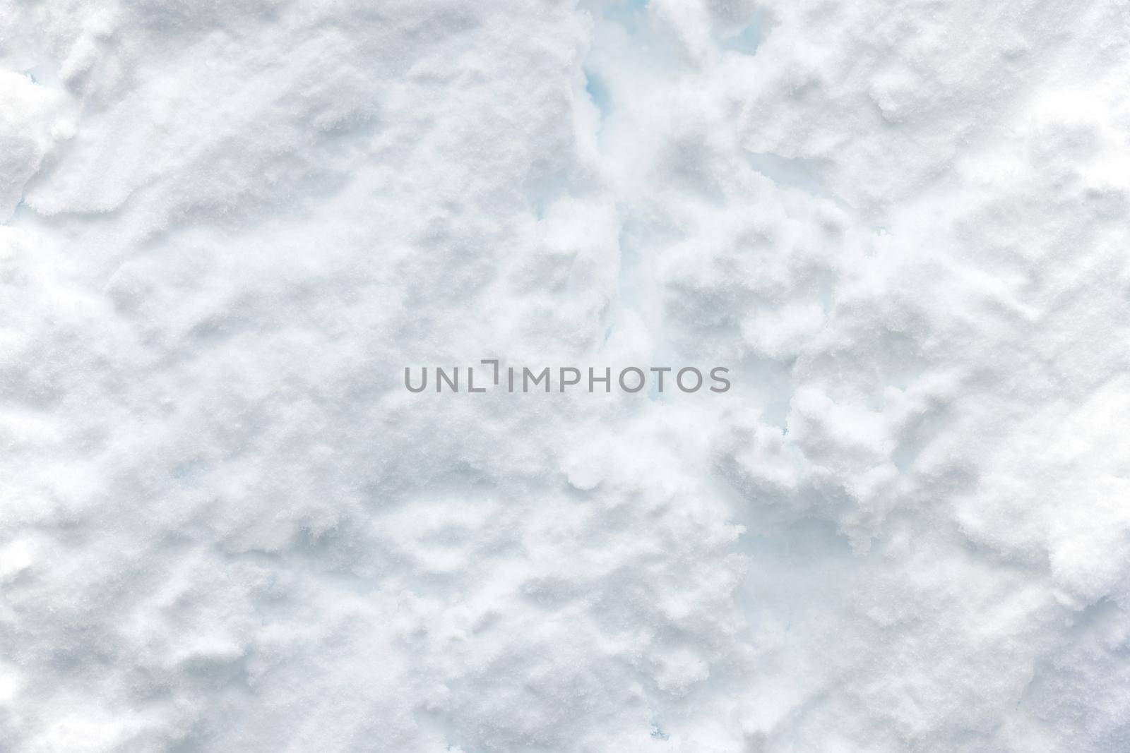 Wall of snow. Snowdrift surface, Winter background. The texture of snow removed with a bucket. Removed compressed snow.