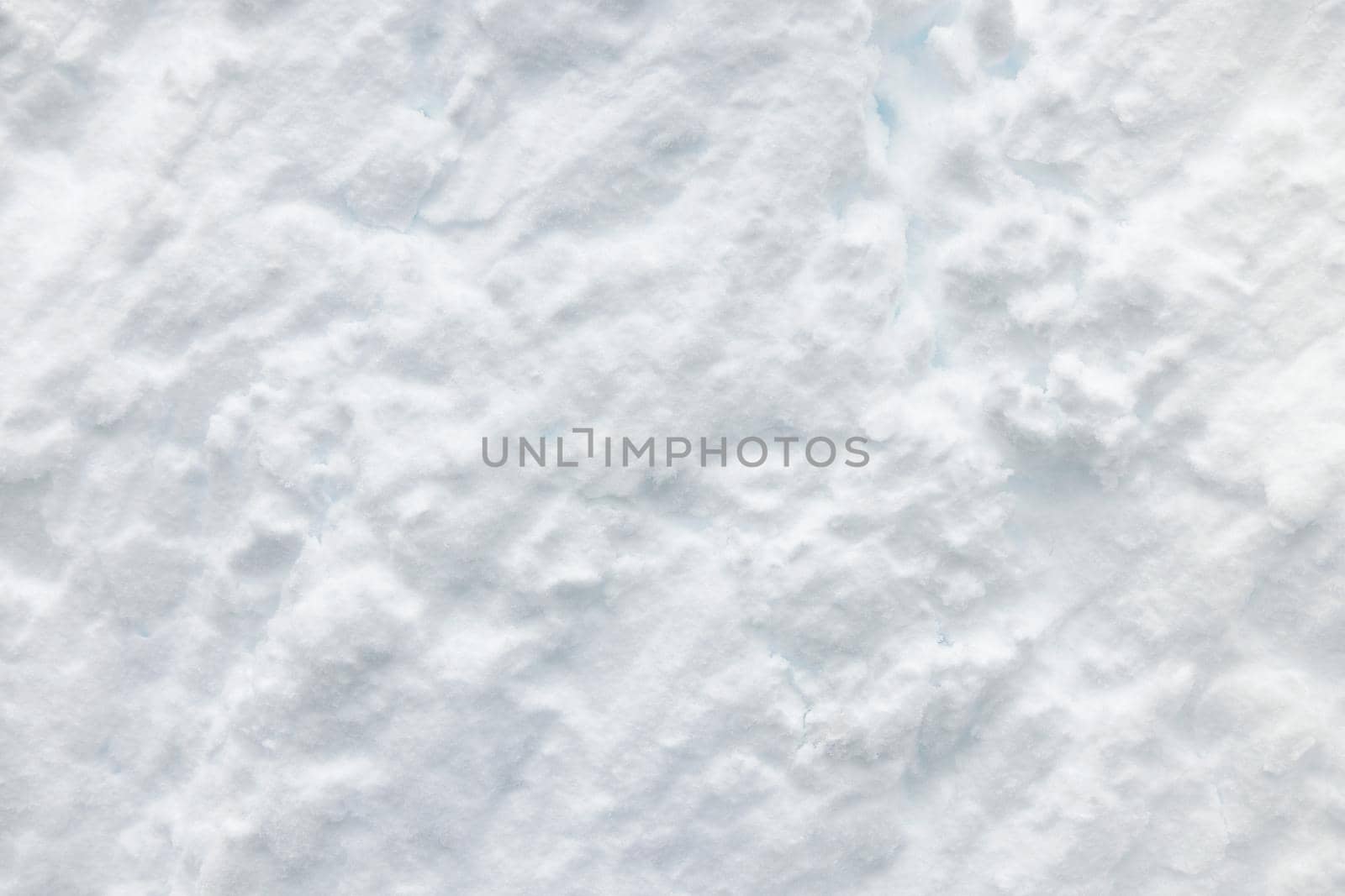 Wall of snow. Snowdrift surface, Winter background. The texture of snow removed with a bucket. Removed compressed snow.