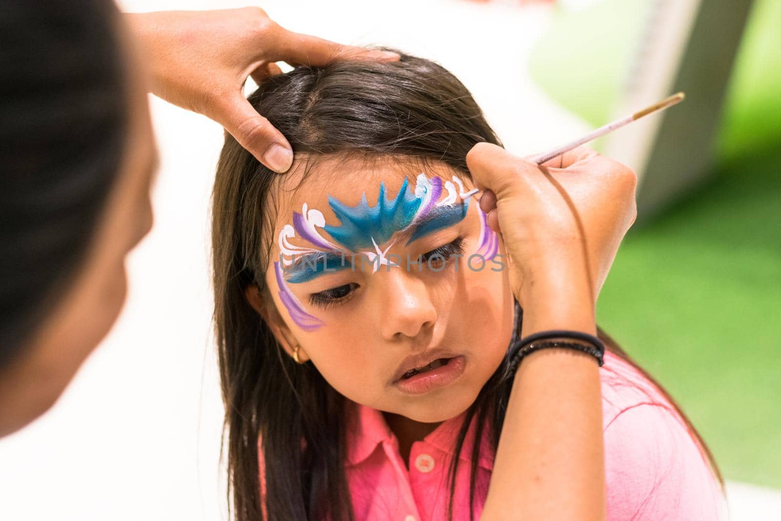 Girl painting her face like a princess by face painting artist. by Peruphotoart