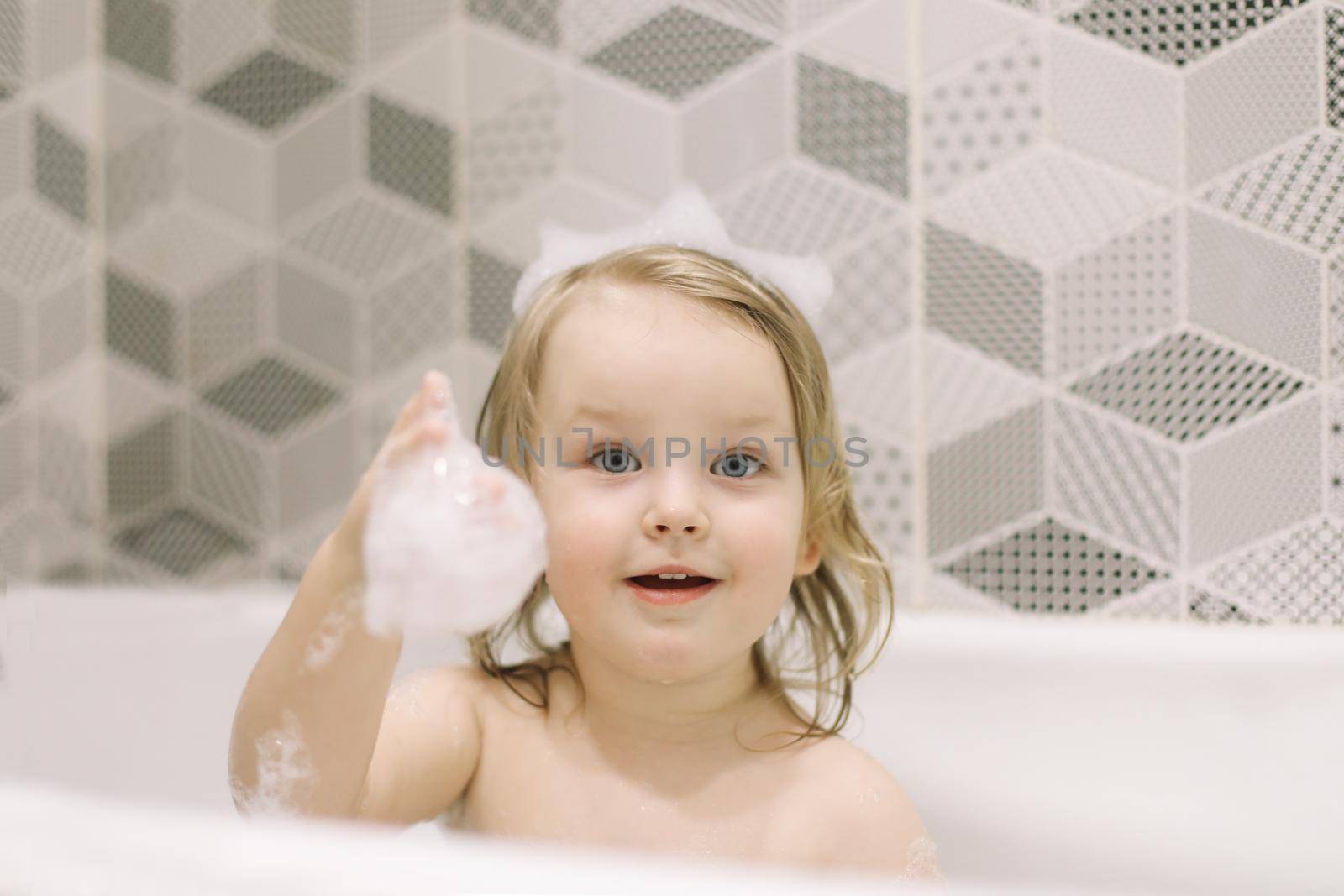 Child bathing. Little baby taking bath, closeup face portrait of smiling girl, health care and kids hygiene. 