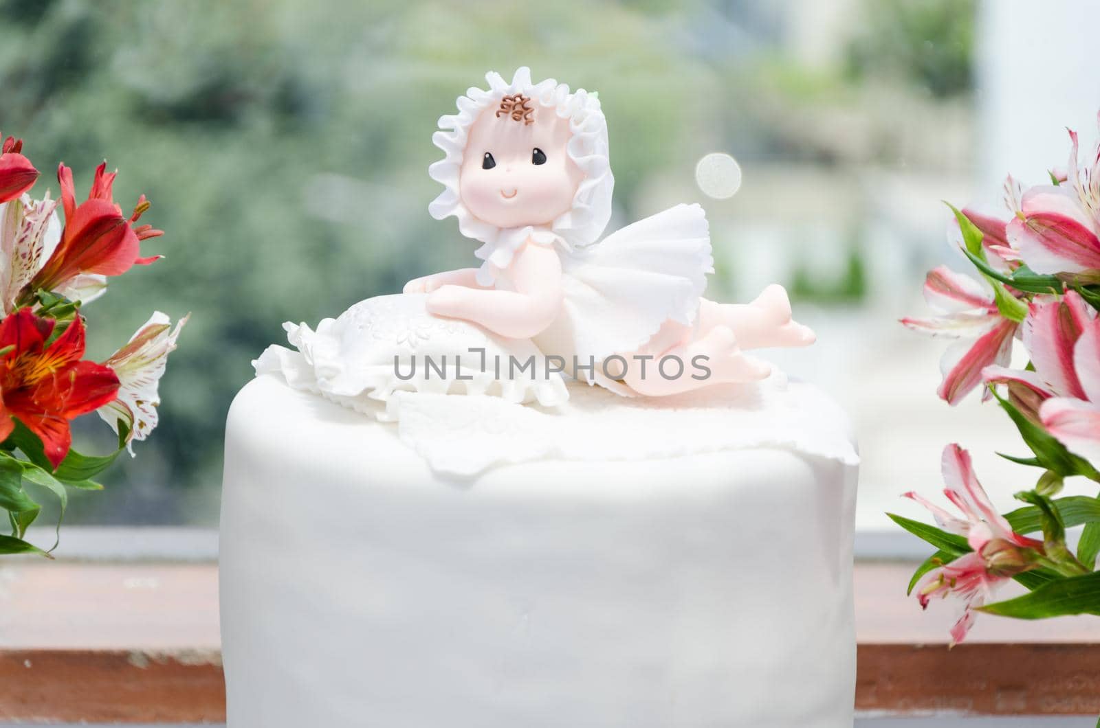 Cake for christening girl. Decorated with a doll and flowers