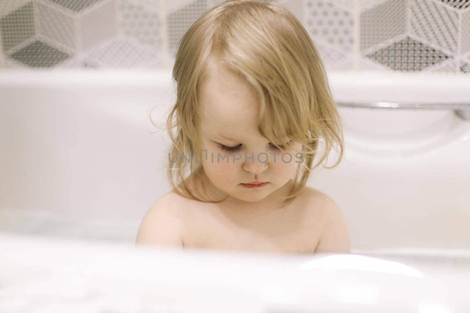 Child bathing. Little baby taking bath, closeup face portrait of smiling girl, health care and kids hygiene. 
