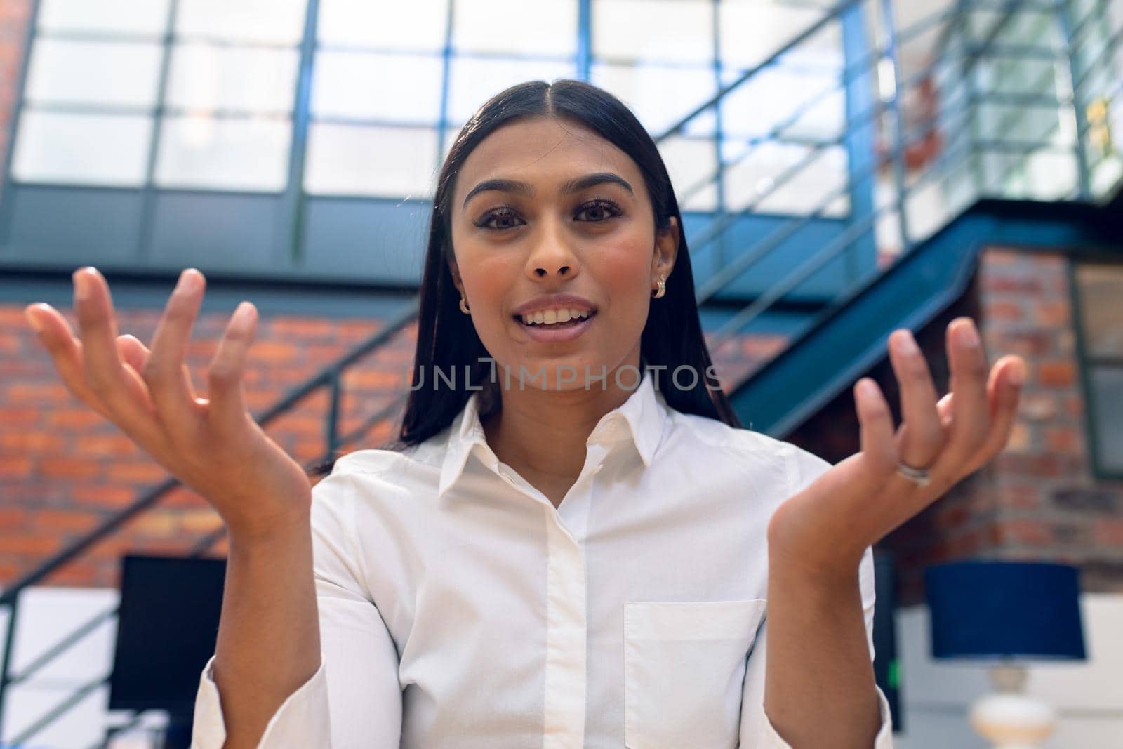 Portrait of biracial young businesswoman gesturing while working in office by Wavebreakmedia