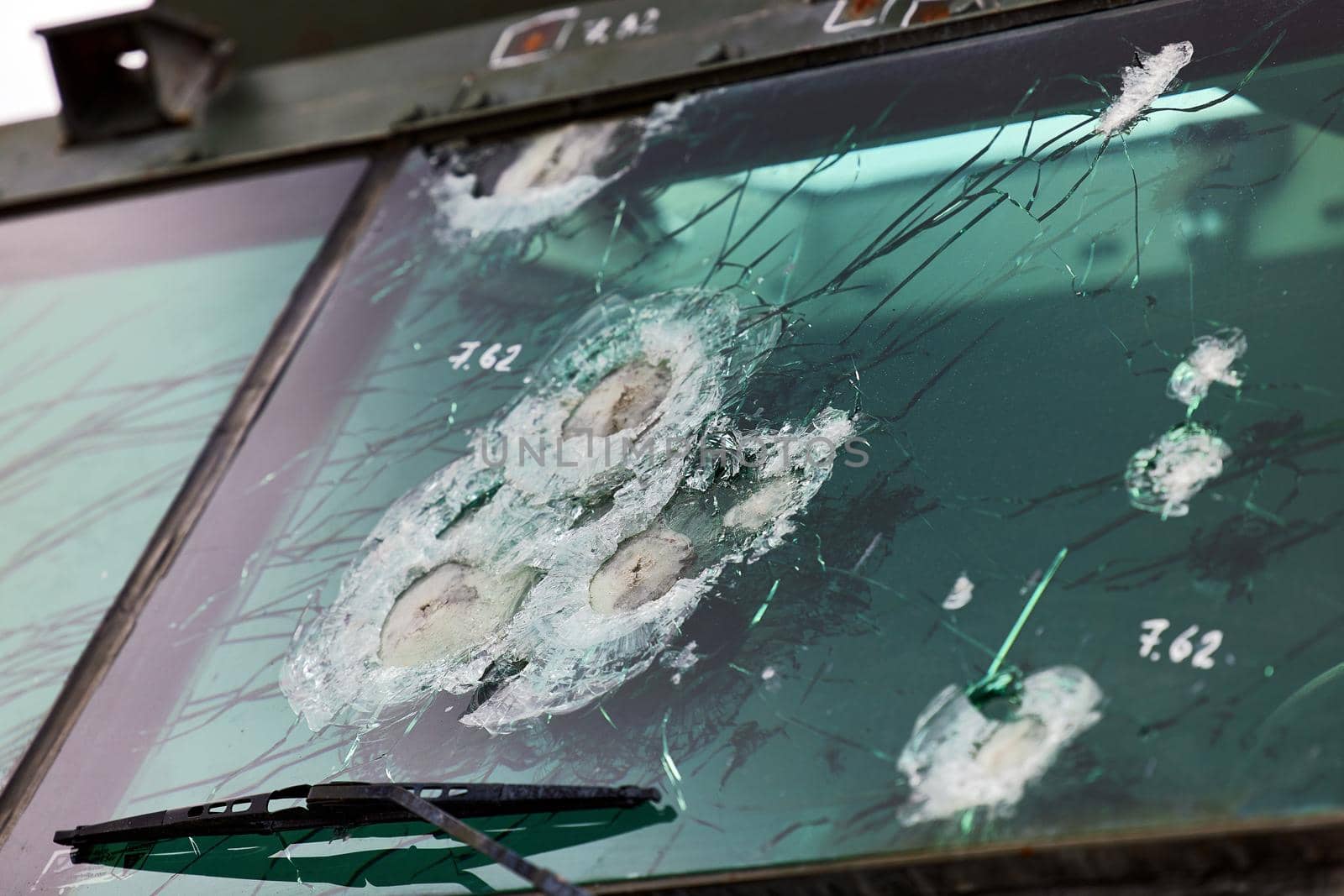 Armored glass after of a direct hit from an automatic weapon. Safety glass after being hit by a bullet. Bulletproof glass armored car after gunshot.