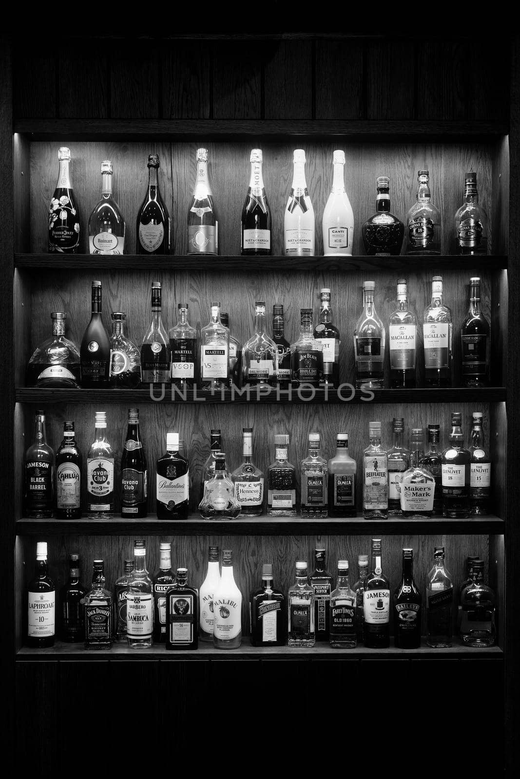 Bottles With Alcoholic in a bar. Bottles of alcoholic beverages are on the shelves. Bar on the wall. 06.06.2021, Rostov region, Russia.