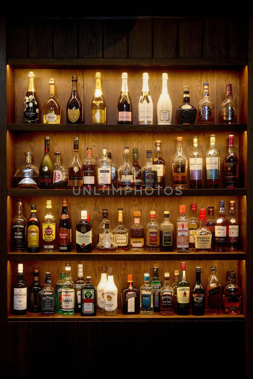 Bottles With Alcoholic in a bar. Bottles of alcoholic beverages are on the shelves. Bar on the wall. 06.06.2021, Rostov region, Russia by EvgeniyQW