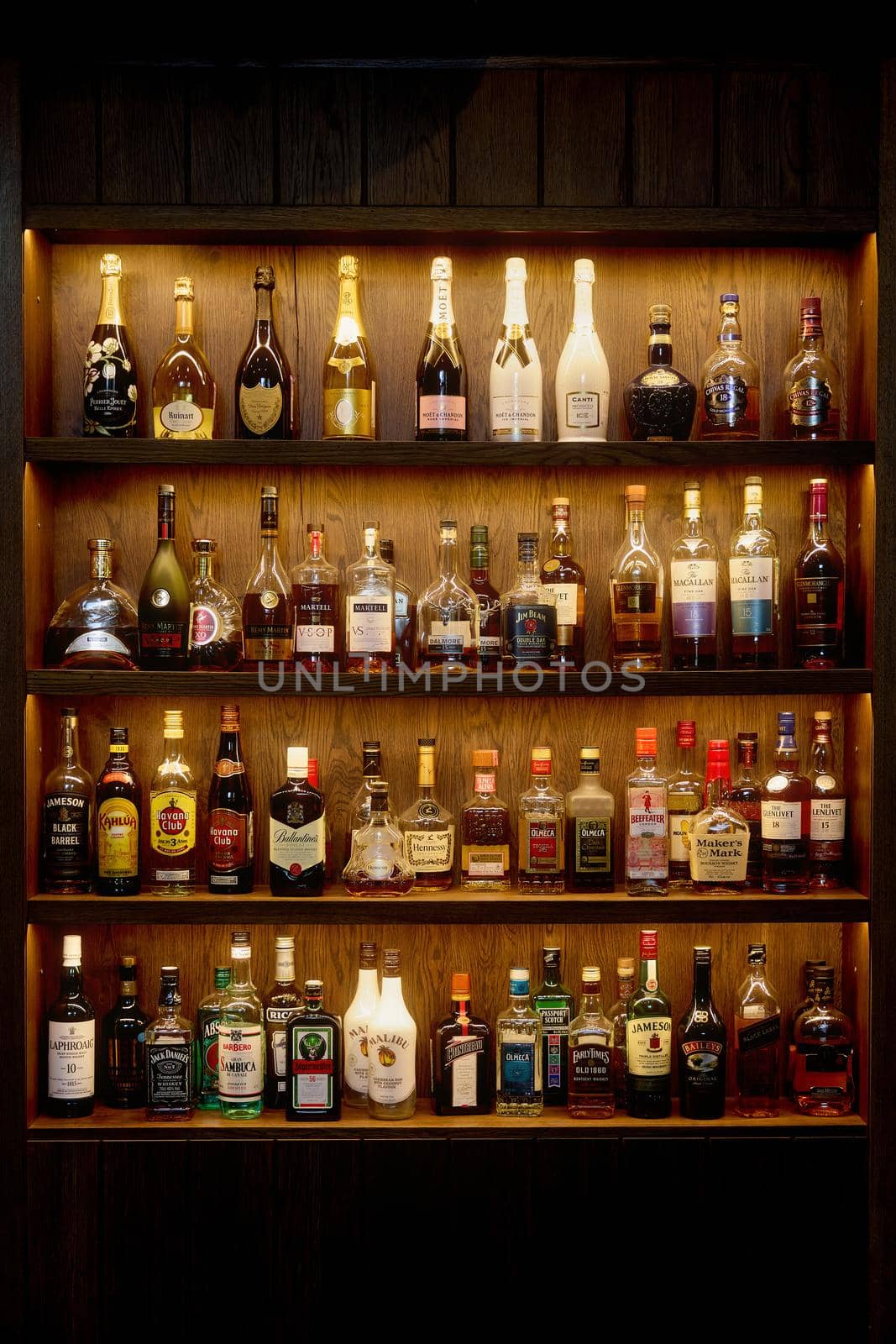 Bottles With Alcoholic in a bar. Bottles of alcoholic beverages are on the shelves. Bar on the wall. 06.06.2021, Rostov region, Russia.