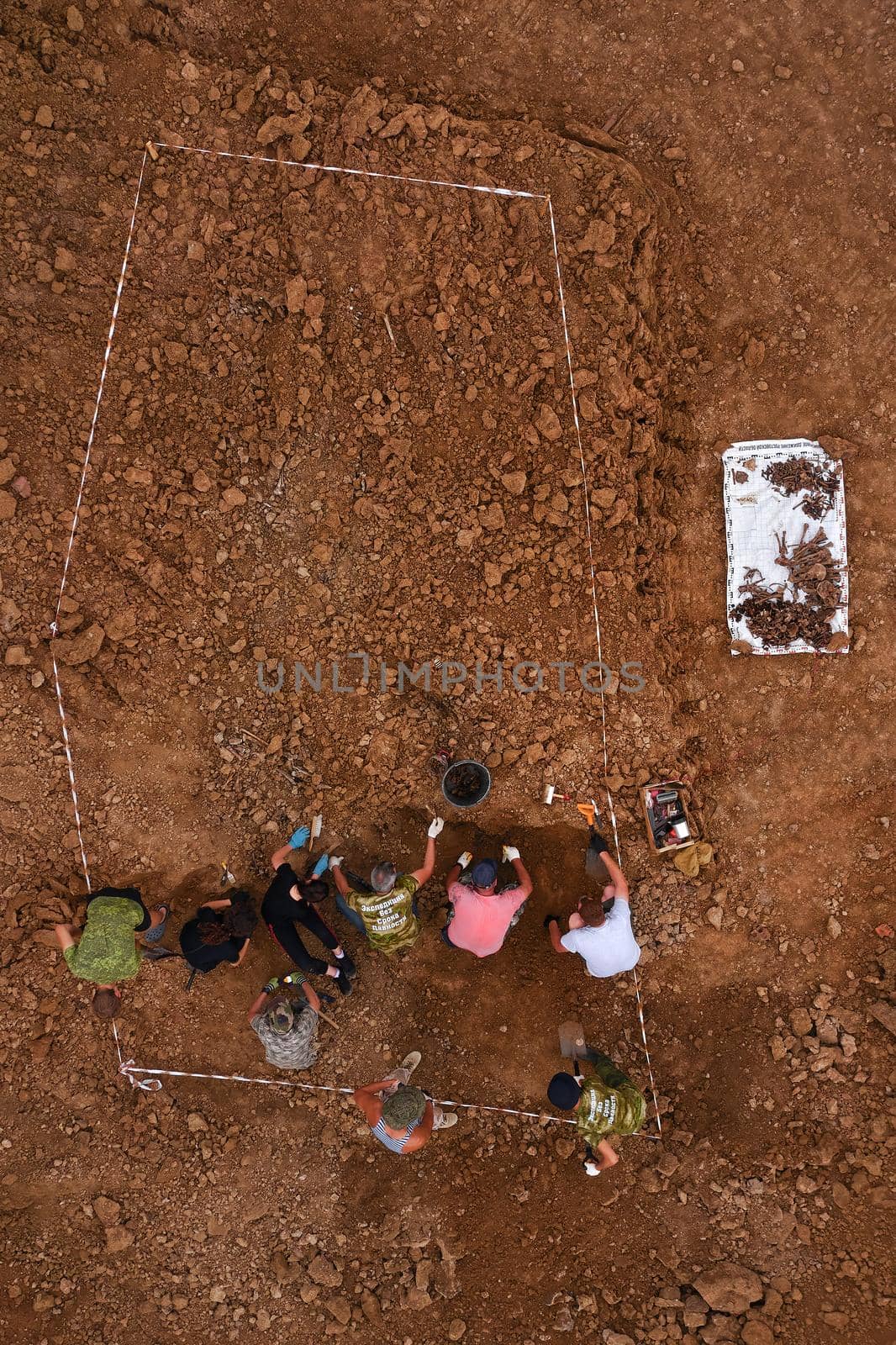 Excavations at the site of a war crime. Site of a mass shooting of people. Human remains bones of skeleton, skulls . Human remains of victims of the Nazis. 28.08.2021, Rostov region, Russia by EvgeniyQW