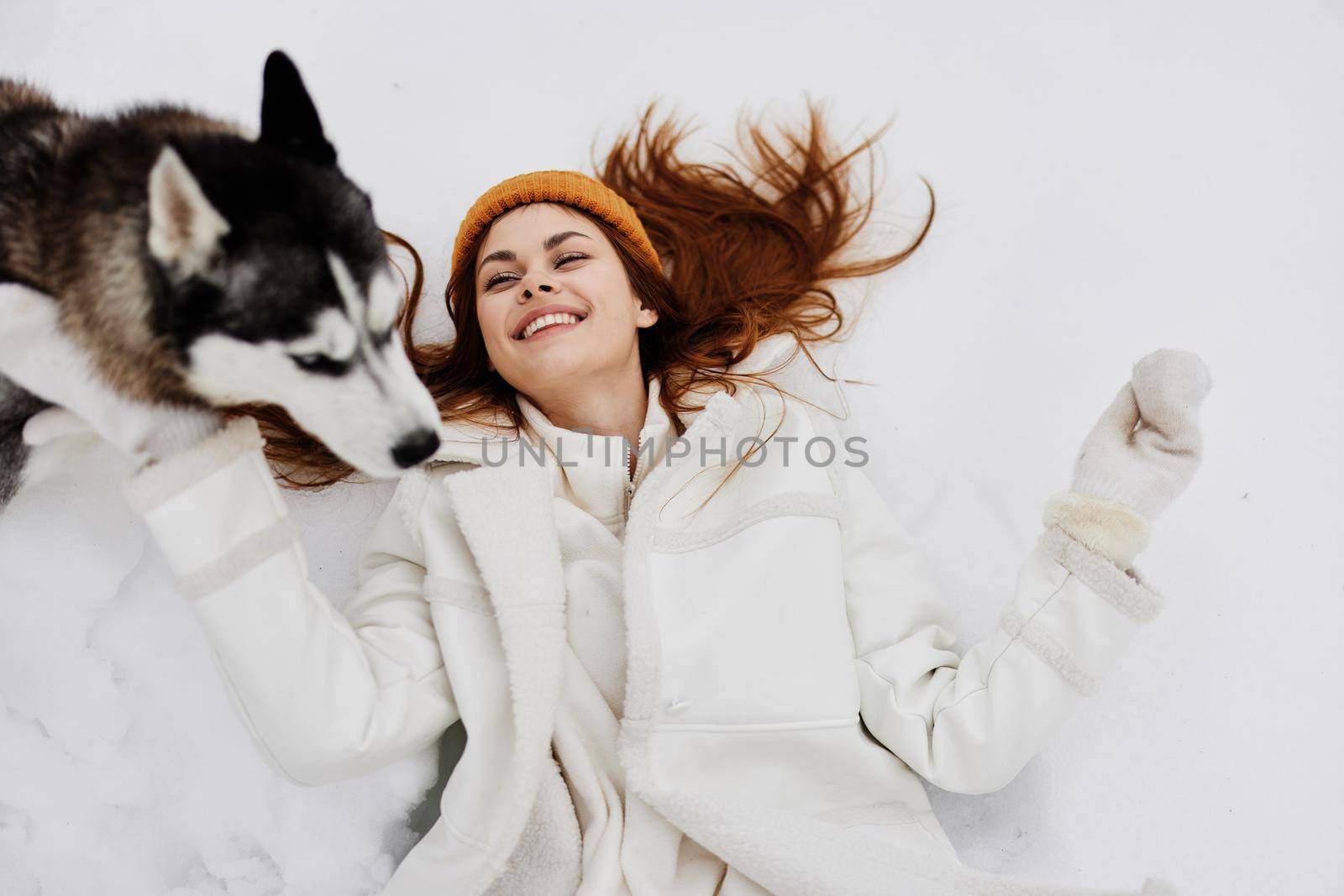 young woman outdoors in a field in winter walking with a dog winter holidays by SHOTPRIME