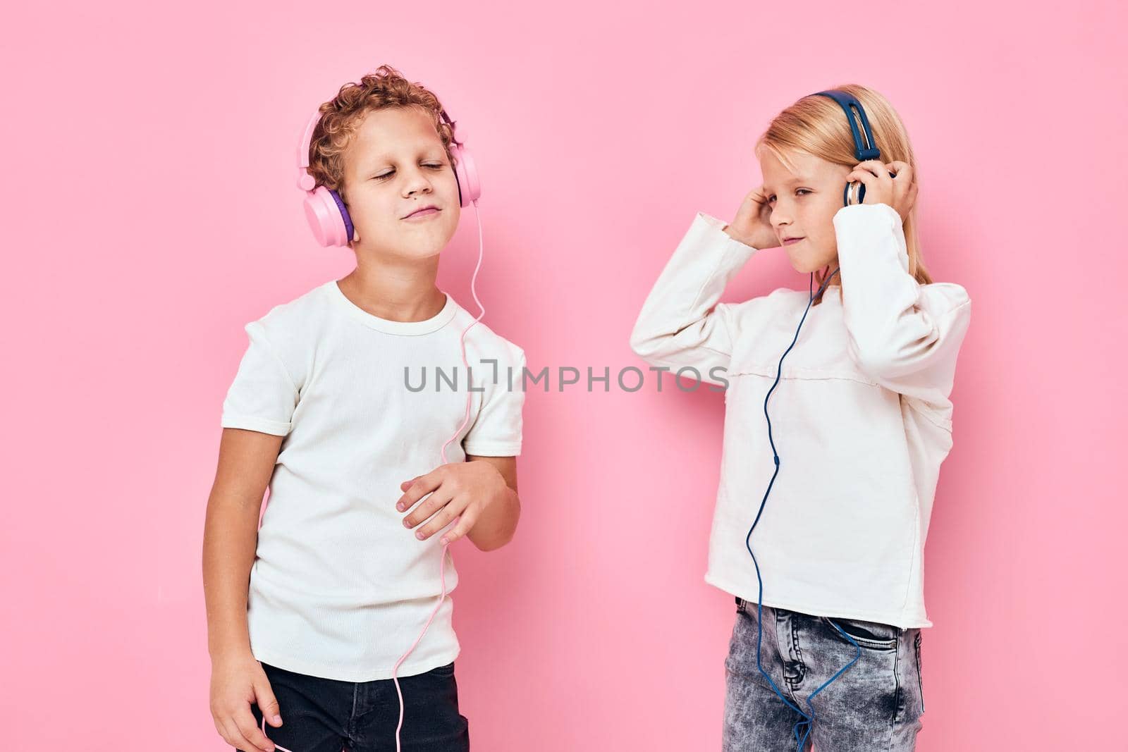 Stylish little boy and cute girl dancing with headphones entertainment studio childhood by SHOTPRIME