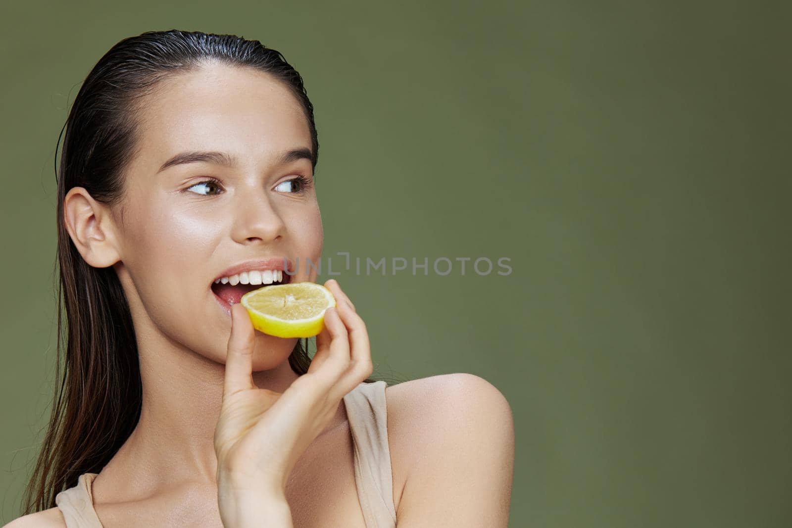 beautiful woman with lemon near face clean skin care health green background. High quality photo