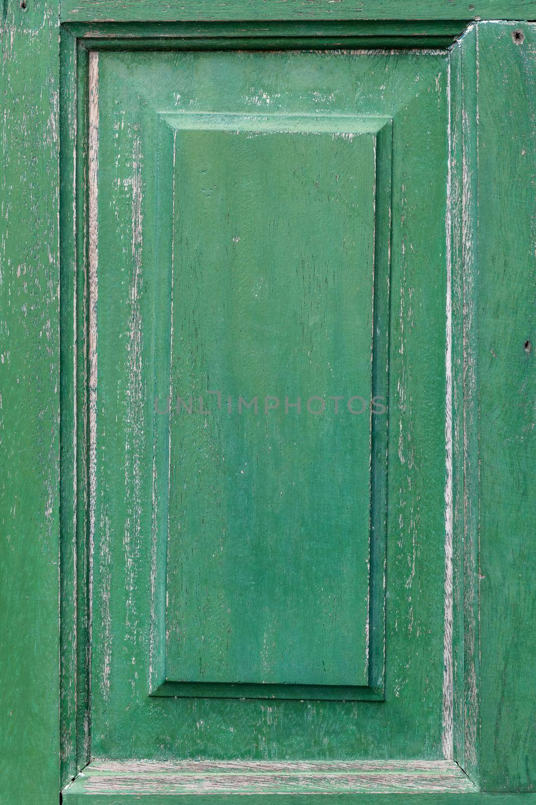 Frame part of a old wooden door painted on green.
