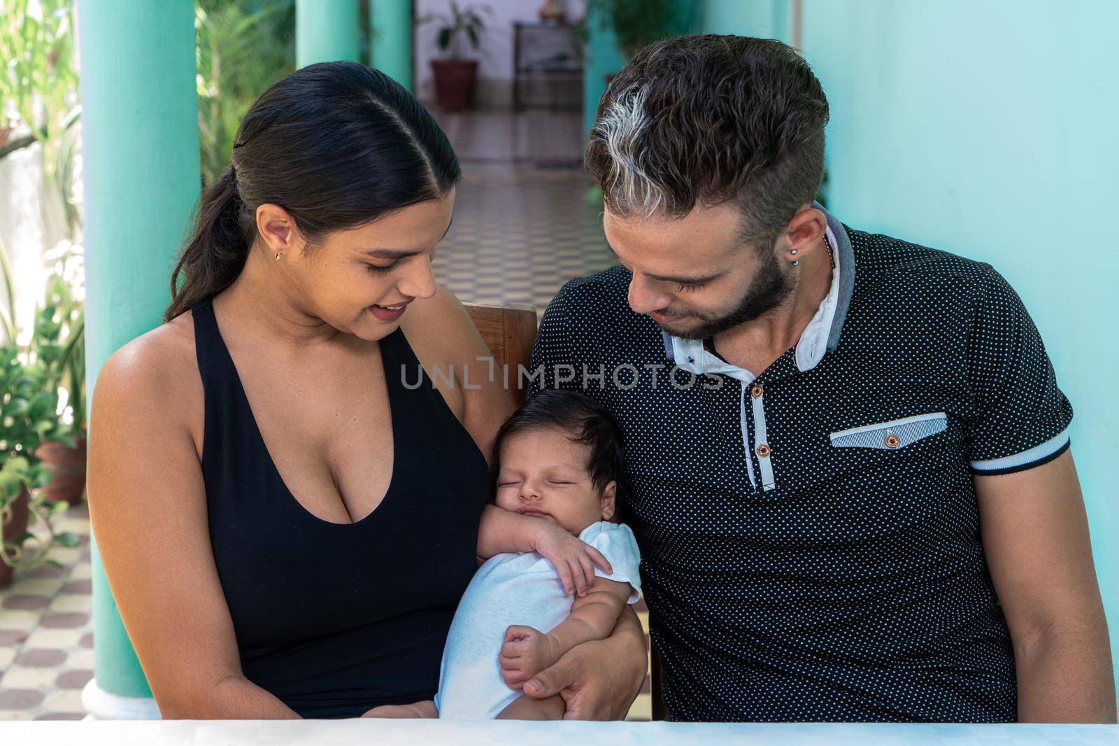 Photo of a baby in the arms of a woman and a man